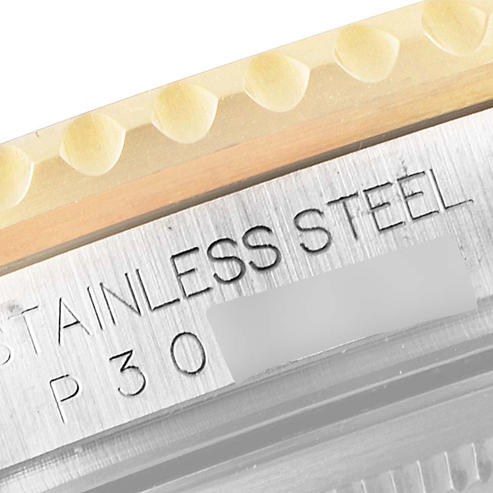 The image shows a close-up of the engraved "STAINLESS STEEL" text on the side of the case of a Rolex GMT-Master 16713 Men's Steel and Gold (two tone) Black Dial 16713 Men's Steel and Gold (two tone) Black Dial watch.