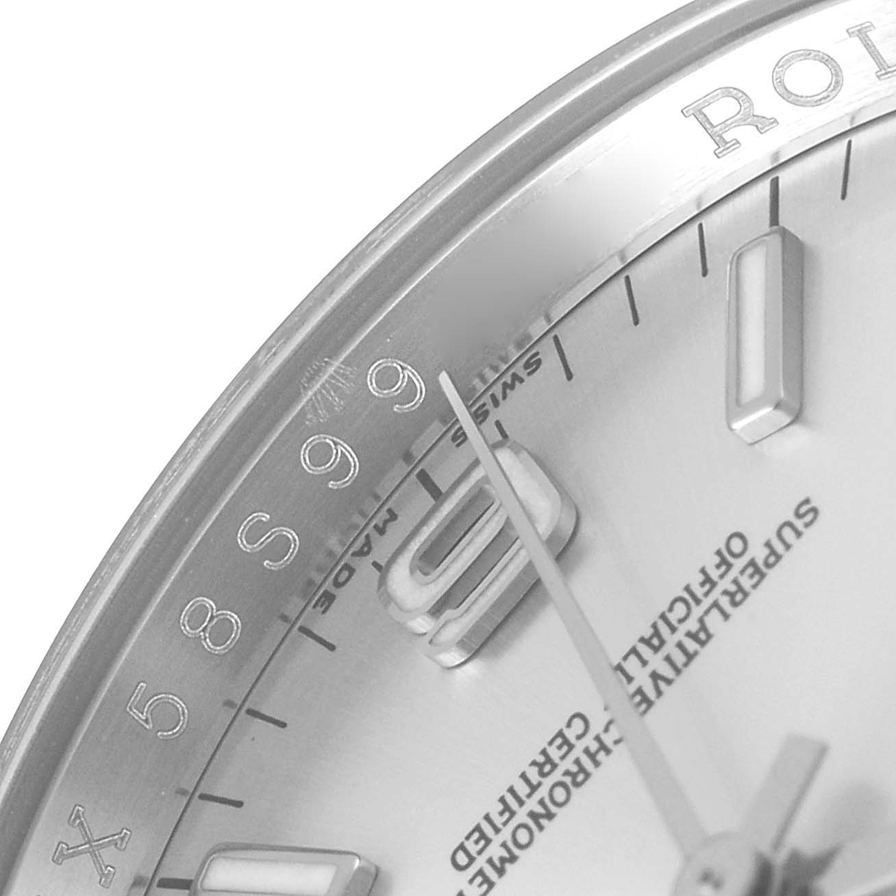 The image shows a close-up of the dial and part of the bezel of a Rolex Oyster Perpetual 116000 Men's Stainless Steel Silver Dial 116000 Men's Stainless Steel Silver Dial watch.
