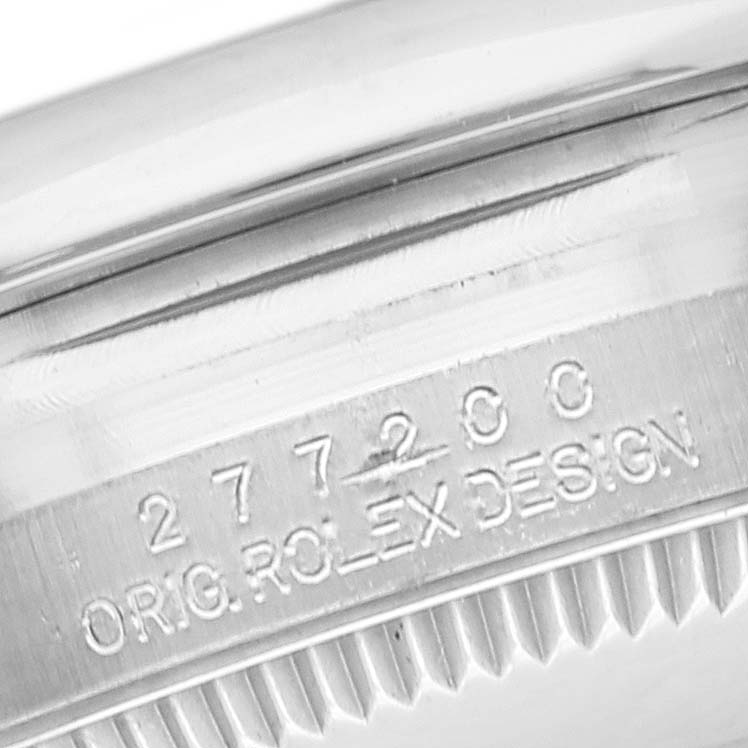 The image shows an angled close-up of the case and bezel of a Rolex Mid-Size 277200 Women's Stainless Steel Pink Dial 277200 Women's Stainless Steel Pink Dial model with engraving.