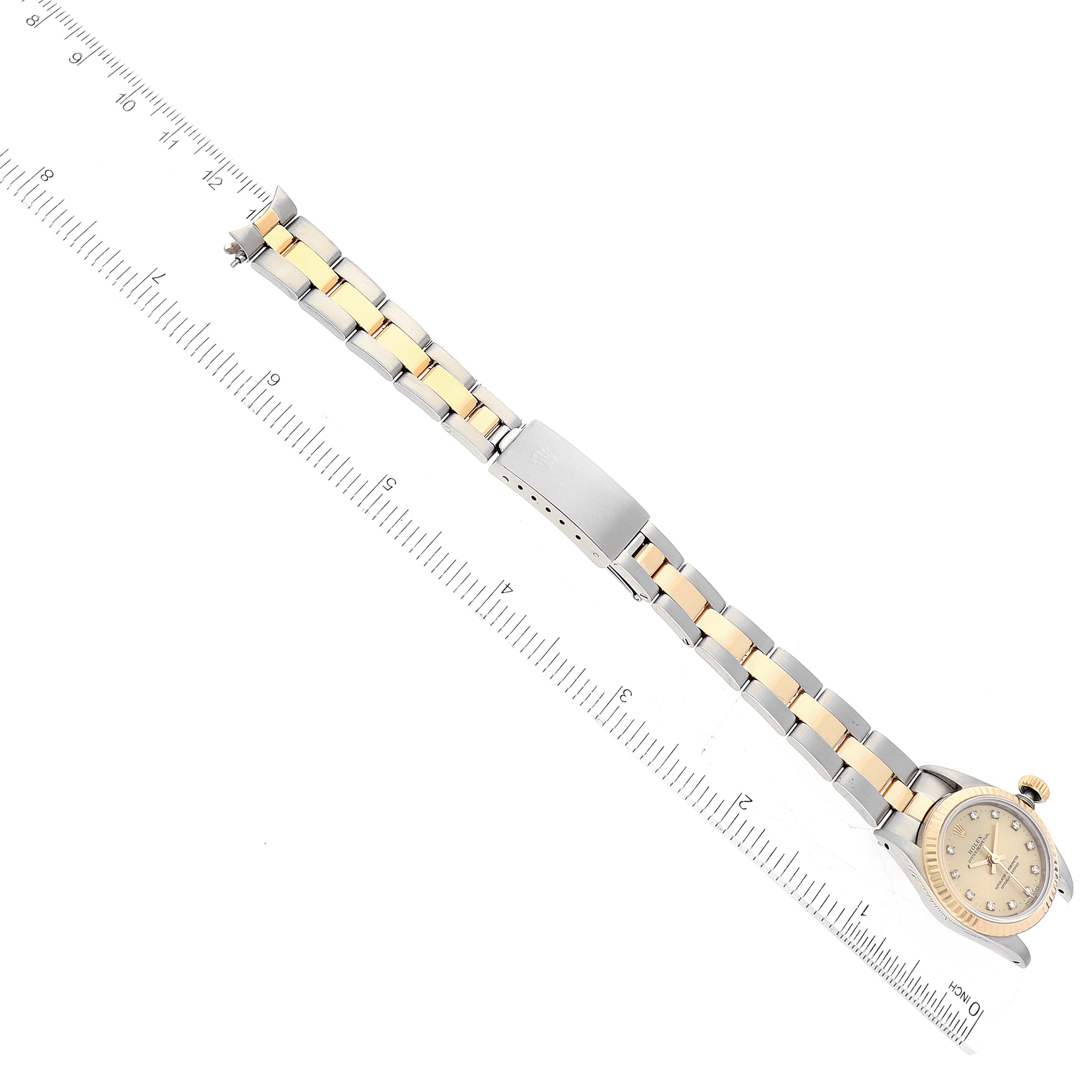 The image shows a Rolex Oyster Perpetual 67193 Women's Steel and Gold (two tone) Champagne Dial 67193 Women's Steel and Gold (two tone) Champagne Dial watch laid flat with its two-tone band and clasp visible, placed next to a ruler for measurement.