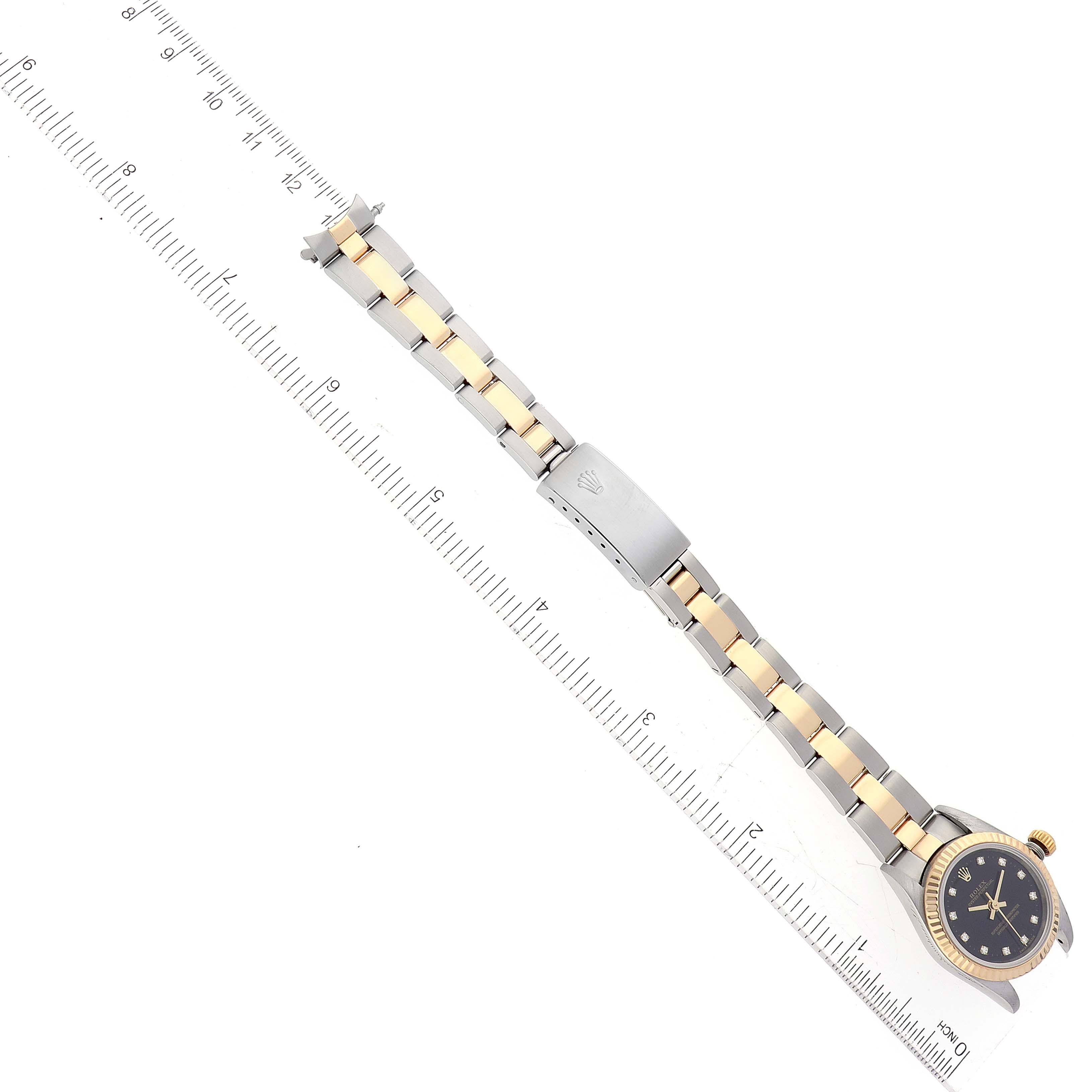 The image shows a Rolex Oyster Perpetual 76193 Women's Steel and Gold (two tone) Black Dial 76193 Women's Steel and Gold (two tone) Black Dial watch lying flat, with its face, bezel, bracelet, and clasp visible, aligned with a ruler.