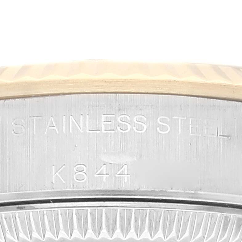 This image shows a close-up of the side of a Rolex Oyster Perpetual 76193 Women's Steel and Gold (two tone) Black Dial 76193 Women's Steel and Gold (two tone) Black Dial watch case, highlighting the "STAINLESS STEEL" engraving.