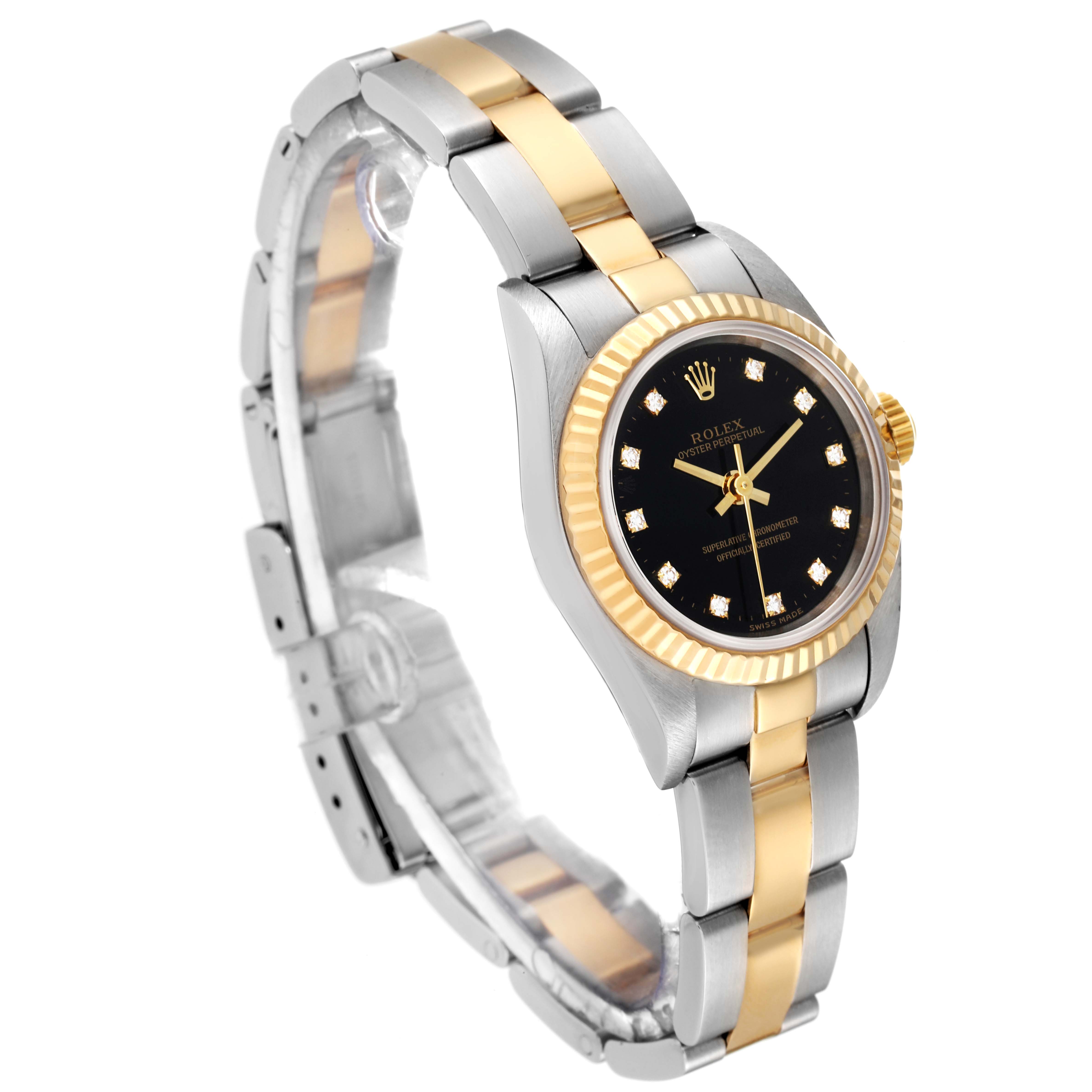 This Rolex Oyster Perpetual 76193 Women's Steel and Gold (two tone) Black Dial 76193 Women's Steel and Gold (two tone) Black Dial watch is shown from an angled side view, highlighting its black dial, gold bezel, and two-tone bracelet.