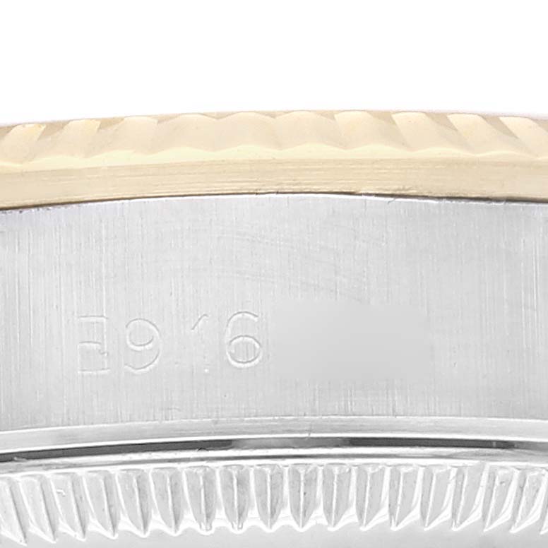 This image shows a close-up view of the case back and part of the bezel of the Rolex Oyster Perpetual 67193 Women's Steel and Gold (two tone) Champagne Dial 67193 Women's Steel and Gold (two tone) Champagne Dial watch.