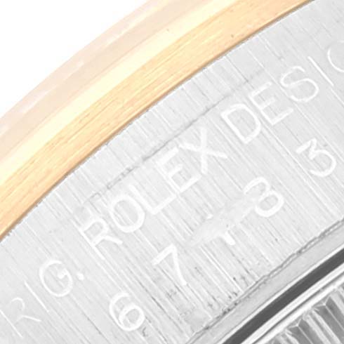 This close-up shows the edge of the bezel and part of the case of a Rolex Oyster Perpetual 67183 Women's Steel and Gold (two tone) Grey Dial 67183 Women's Steel and Gold (two tone) Grey Dial watch, featuring engraved branding and design details.