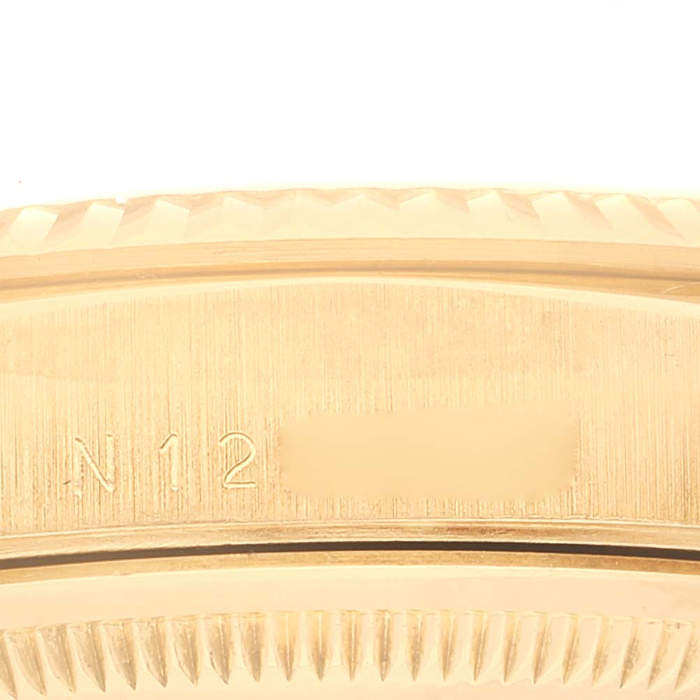 This image shows a close-up of the side of a Rolex President 18238 Men's Yellow Gold Champagne Dial 18238 Men's Yellow Gold Champagne Dial model, focusing on the engraved serial number and fluted bezel.