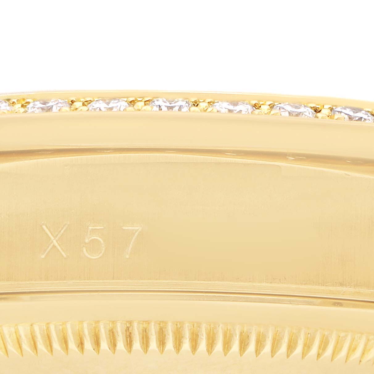 The image shows a close-up of a section of the bezel with diamond accents on a Rolex President 18388 Men
s Yellow Gold Champagne Dial model watch, featuring an engraving.