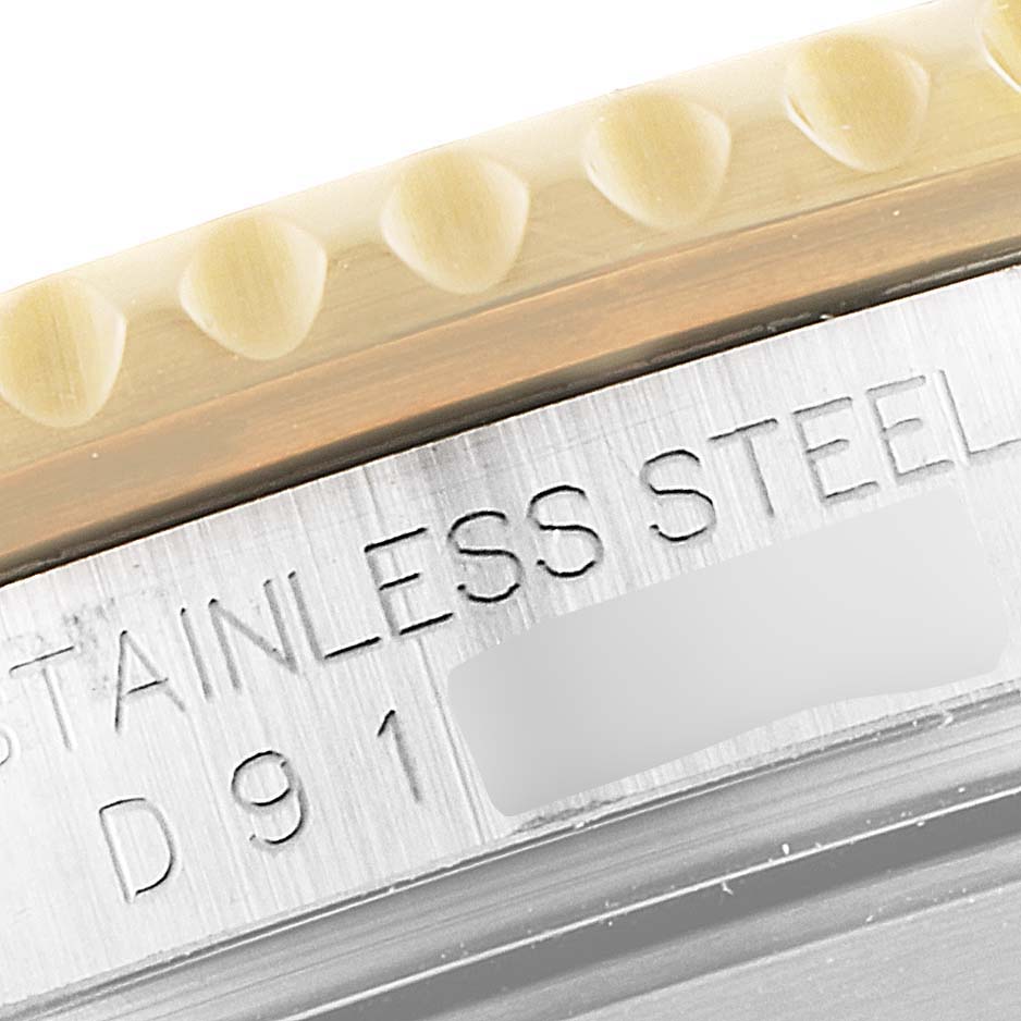 This close-up image shows the bezel edge and part of the stainless steel case back with an engraving on the Rolex Submariner 16613 Men's Steel and Gold (two tone) Black Dial 16613 Men's Steel and Gold (two tone) Black Dial watch.