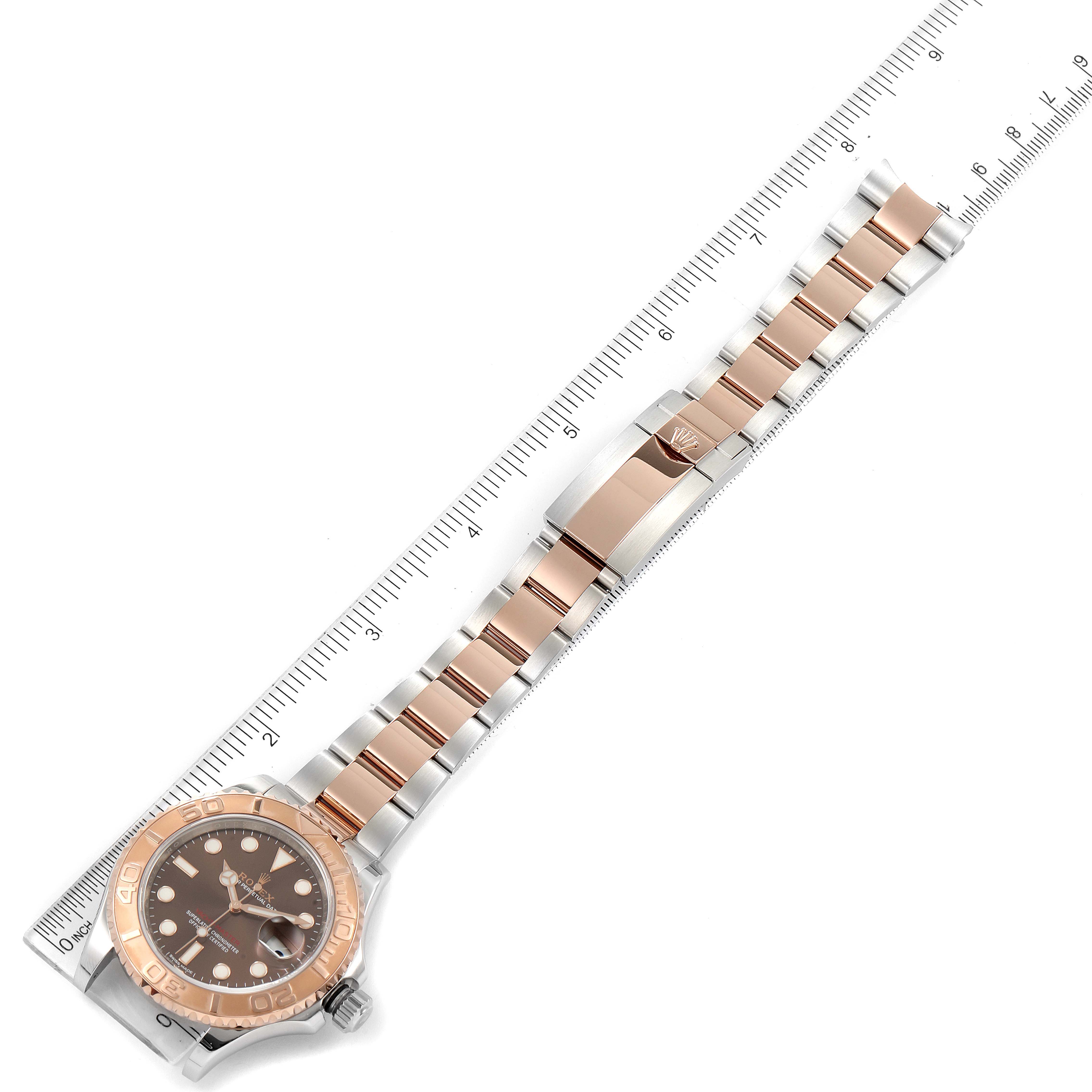 The image shows the Rolex Yacht-Master 116621 Men's Steel and Gold (two tone) Brown Dial 116621 Men's Steel and Gold (two tone) Brown Dial watch laid flat, showcasing the face, bezel, and bracelet with a ruler for scale.