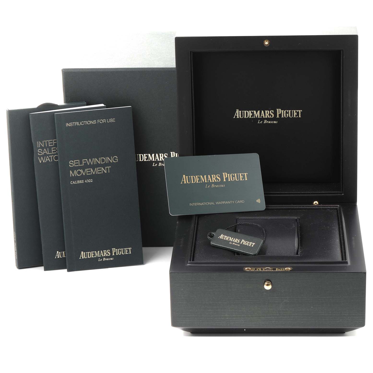 The image shows the packaging, instruction manuals, warranty card, and box for a Royal Oak watch by Audemars Piguet.