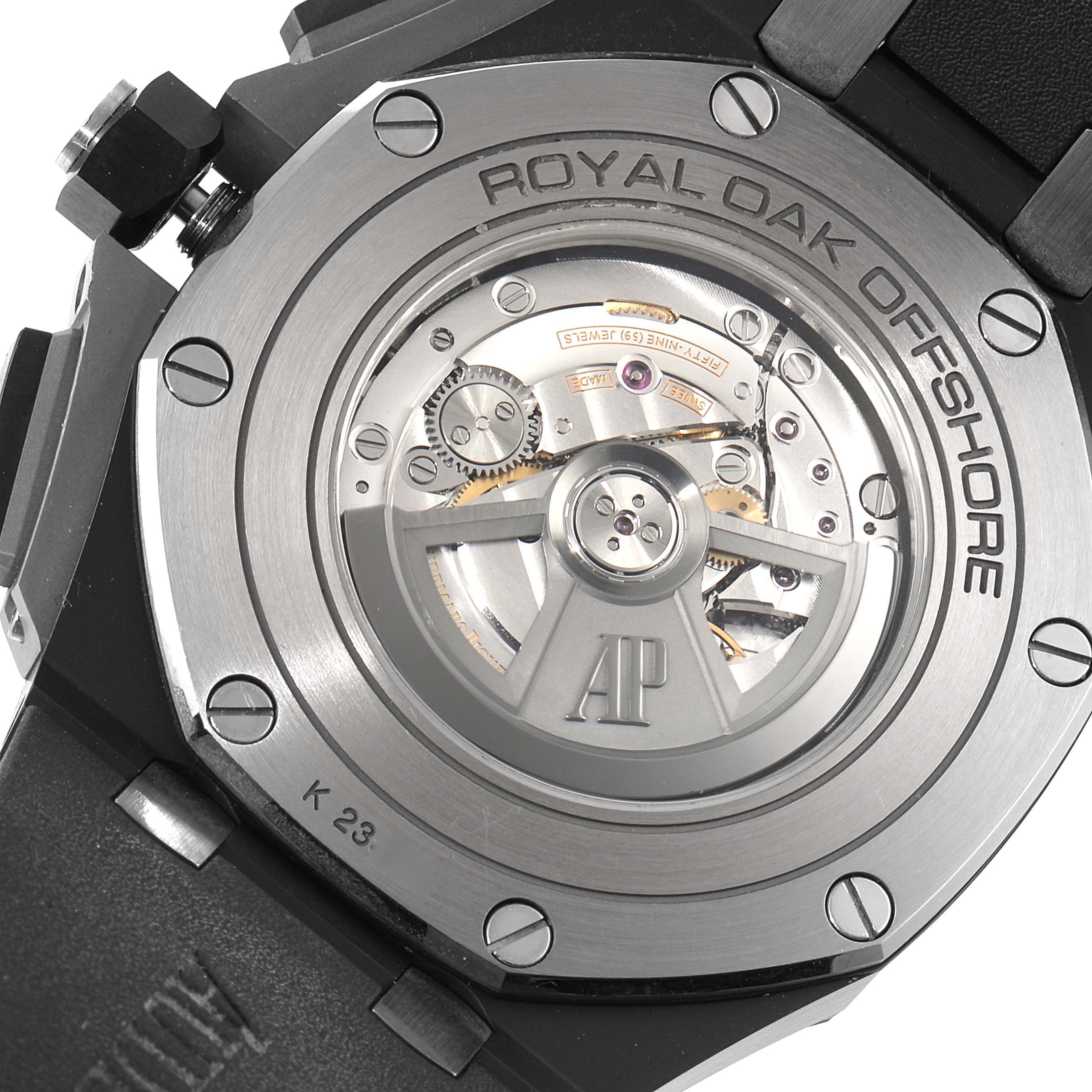 The image shows the back of an Audemars Piguet Royal Oak Offshore 26405CE.OO.A002CA.02 Men's Ceramic Black Dial 26405CE.OO.A002CA.02 Men's Ceramic Black Dial watch, revealing its mechanical movement and rotor.