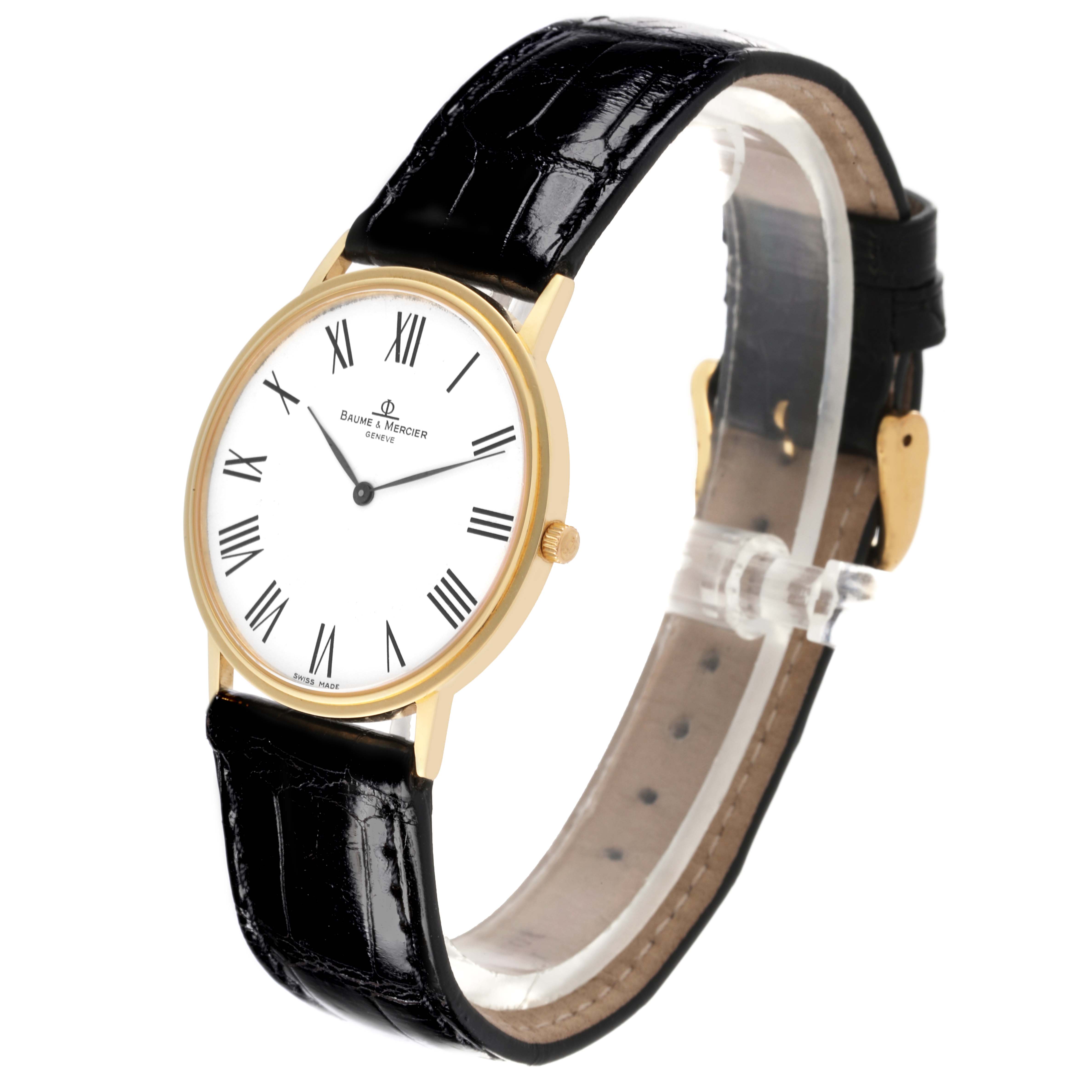 The Baume & Mercier Classima MV045088 Men's Yellow Gold White Dial MV045088 Men's Yellow Gold White Dial watch is shown at a three-quarter angle, displaying its face, gold case, crown, and black leather strap.