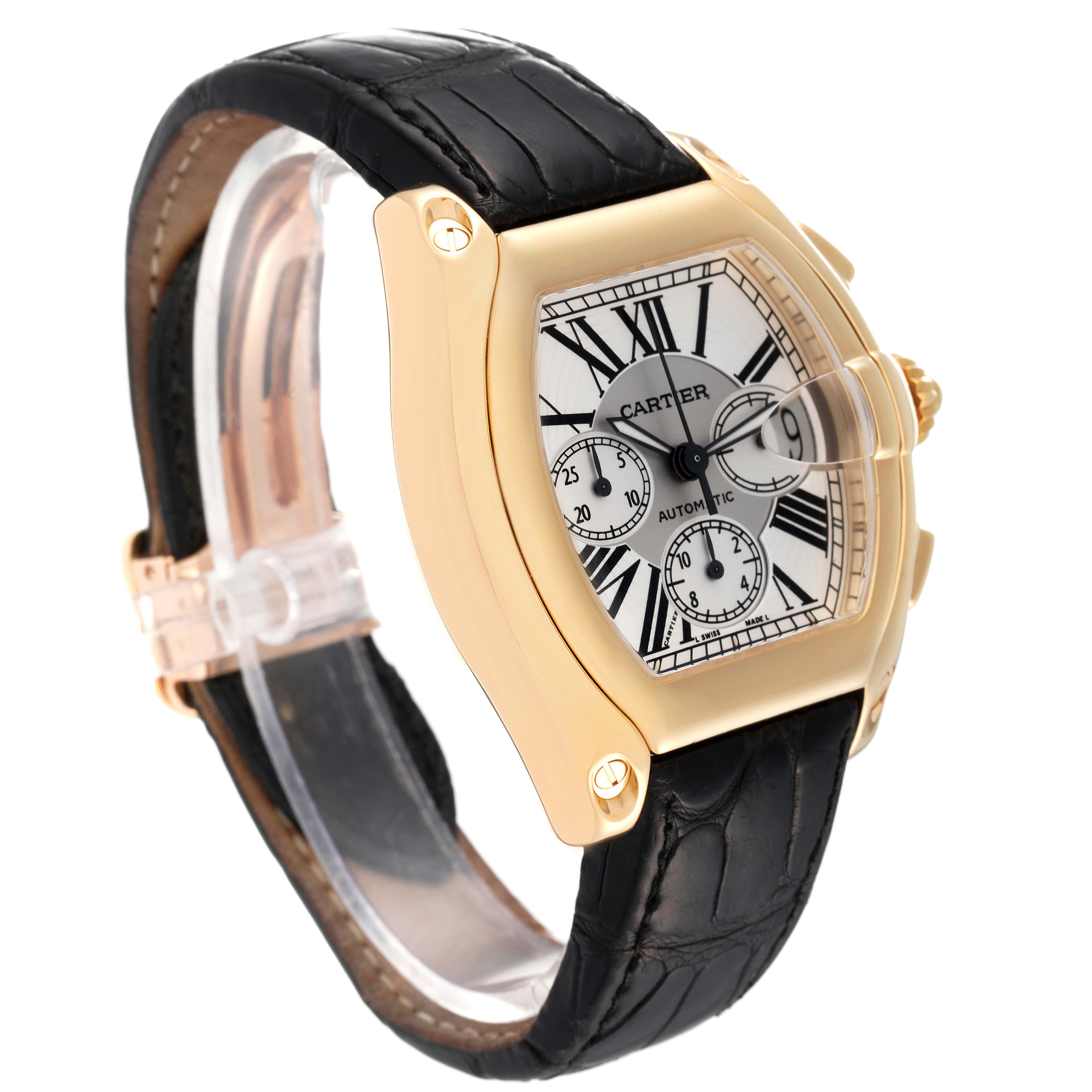 The Cartier Roadster W62021Y3 Men's Yellow Gold Silver Dial W62021Y3 Men's Yellow Gold Silver Dial watch is shown at an angle highlighting its gold case, black leather strap, and detailed dial.