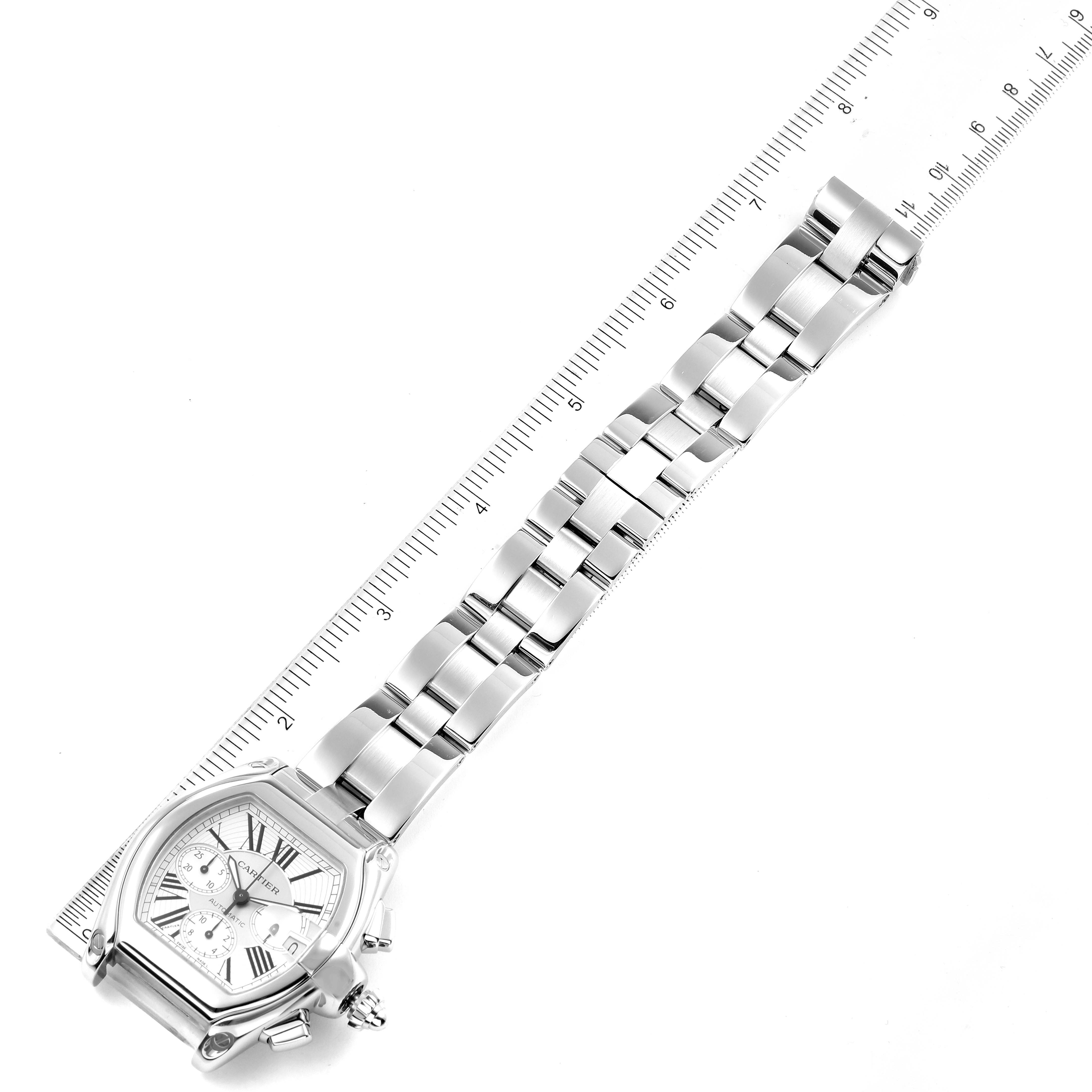 The Cartier Roadster W62019X6 Men's Stainless Steel Silver Dial W62019X6 Men's Stainless Steel Silver Dial watch is shown from an angled top view, displaying the full face and bracelet against a ruler.