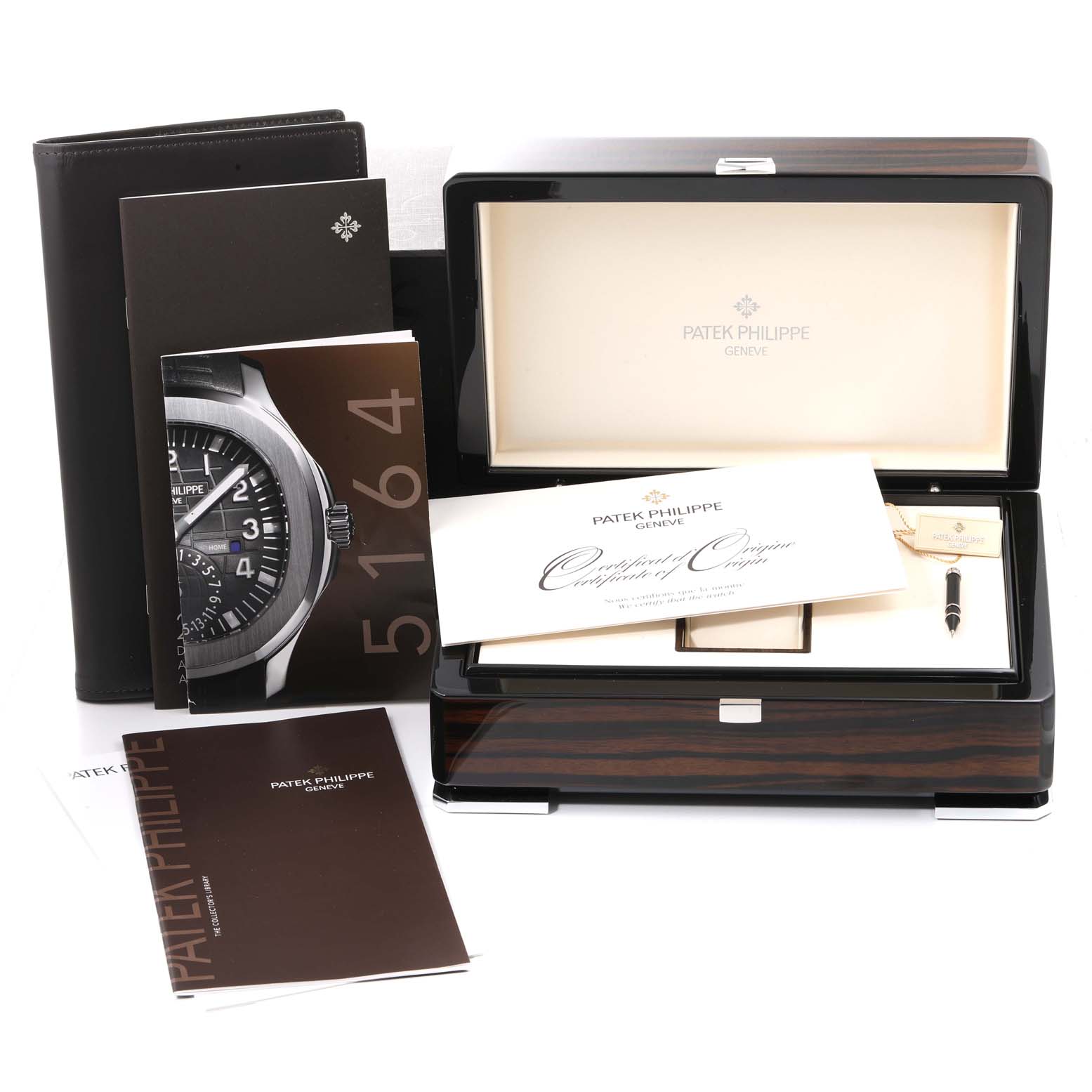 The image shows a Patek Philippe Aquanaut 5164A Men's Stainless Steel Black Dial 5164A Men's Stainless Steel Black Dial watch's box and accessories, including manuals, certificate, and a pen, all from a front-angle view.