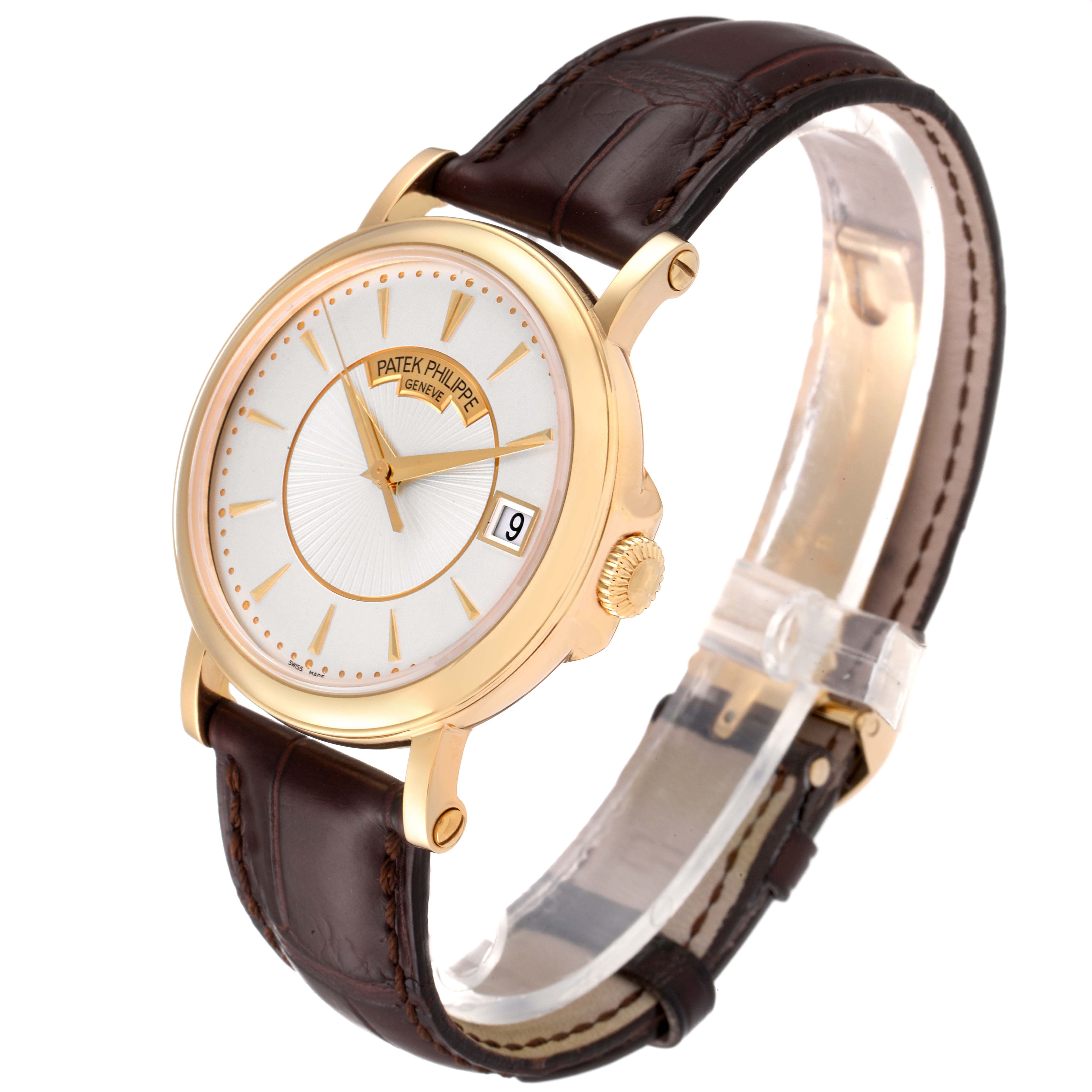 The image shows a Patek Philippe Calatrava 5153J Men's Yellow Gold Silver Dial 5153J Men's Yellow Gold Silver Dial watch at a three-quarter angle, featuring its dial, crown, and leather strap.
