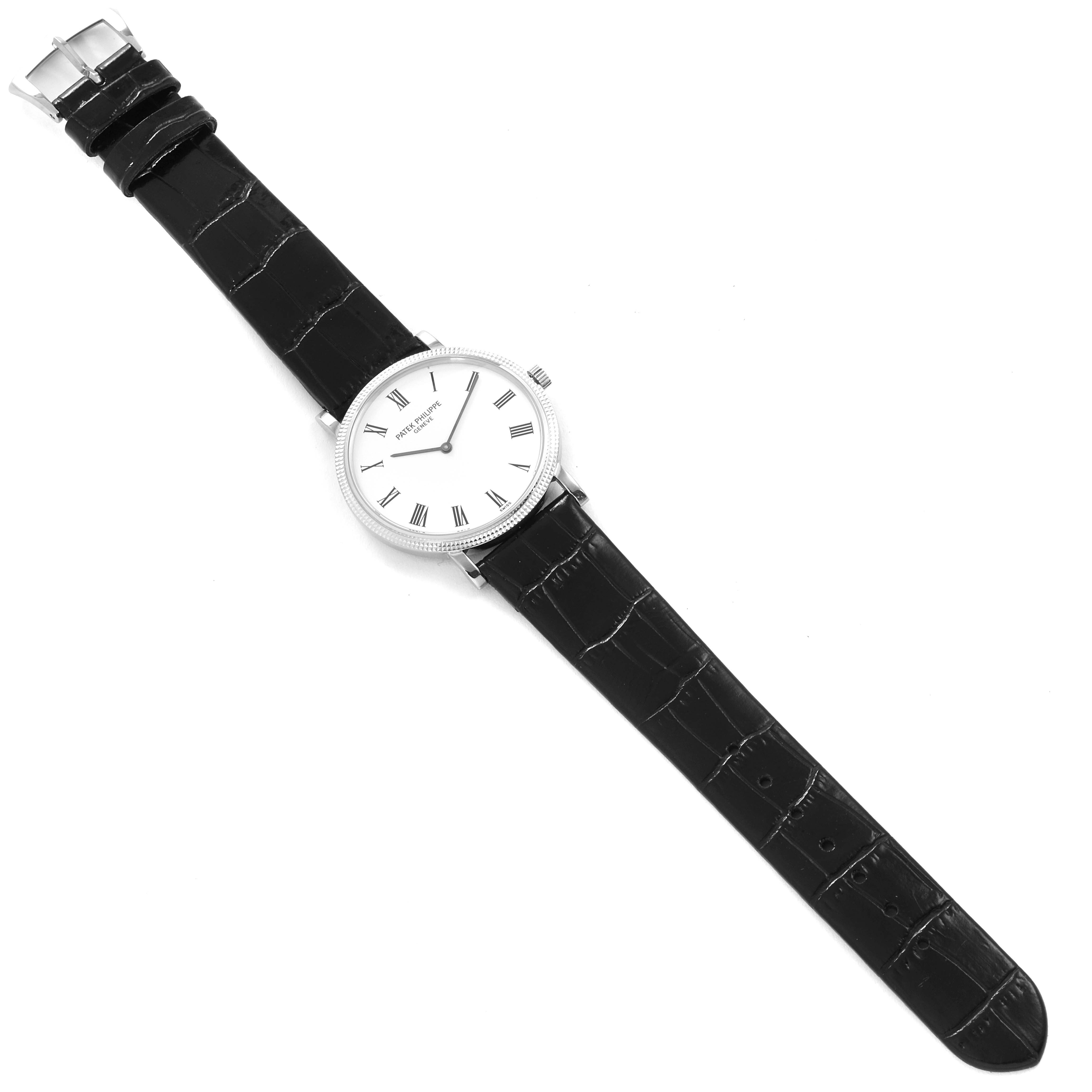 The image shows an overhead view of a Patek Philippe Calatrava 5120G Men's White Gold White Dial 5120G Men's White Gold White Dial watch with a black leather strap and white dial.