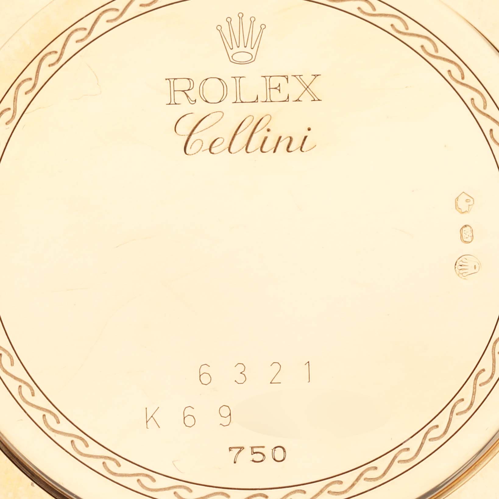 The image shows a close-up of the back case of a Rolex Cellini 6321 Women's Yellow Gold Mother of Pearl Dial 6321 Women's Yellow Gold Mother of Pearl Dial watch, featuring engravings and hallmark symbols.