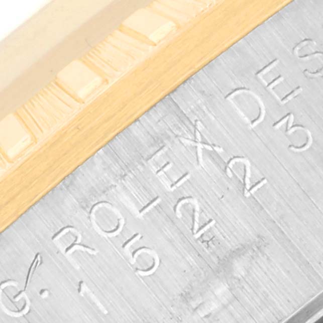 The image shows a close-up of the engraved rehaut and fluted bezel of a Rolex Date 15223 Men's Steel and Gold (two tone) Champagne Dial 15223 Men's Steel and Gold (two tone) Champagne Dial model.