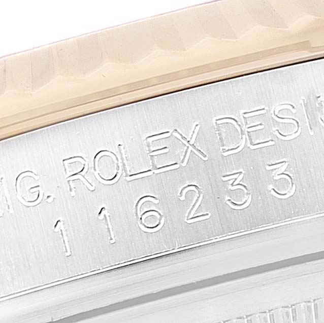 The image shows a close-up angle of the serial number engraving on a Rolex Datejust 116233 Men's Steel and Gold (two tone) Black Dial 116233 Men's Steel and Gold (two tone) Black Dial watch case.