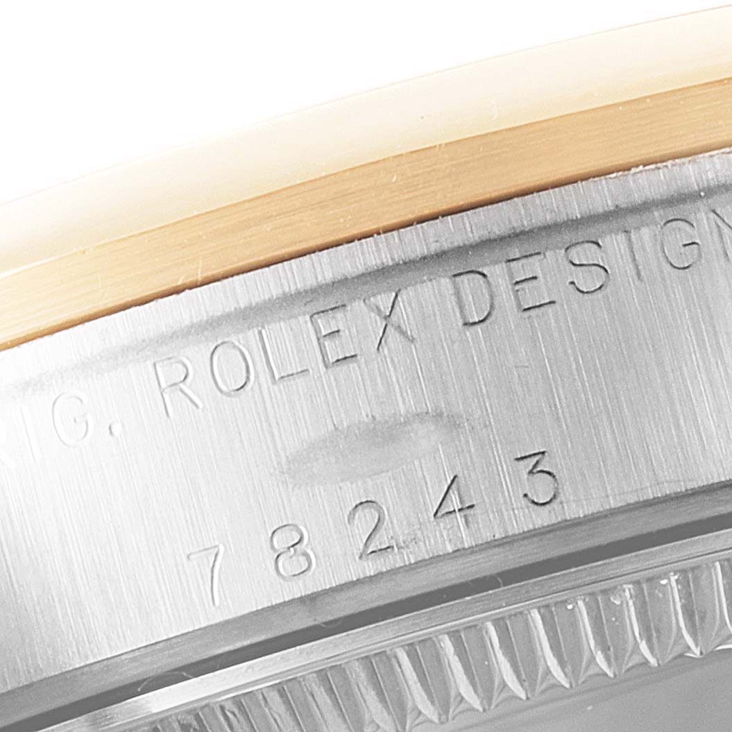 The image shows a close-up of the case sides and bezel of a Rolex Mid-Size 78243 Women
s Steel and Gold (two tone) White Dial 78243 Women
s Steel and Gold (two tone) White Dial model, specifically highlighting the engraved serial number and "Rolex Design" text.