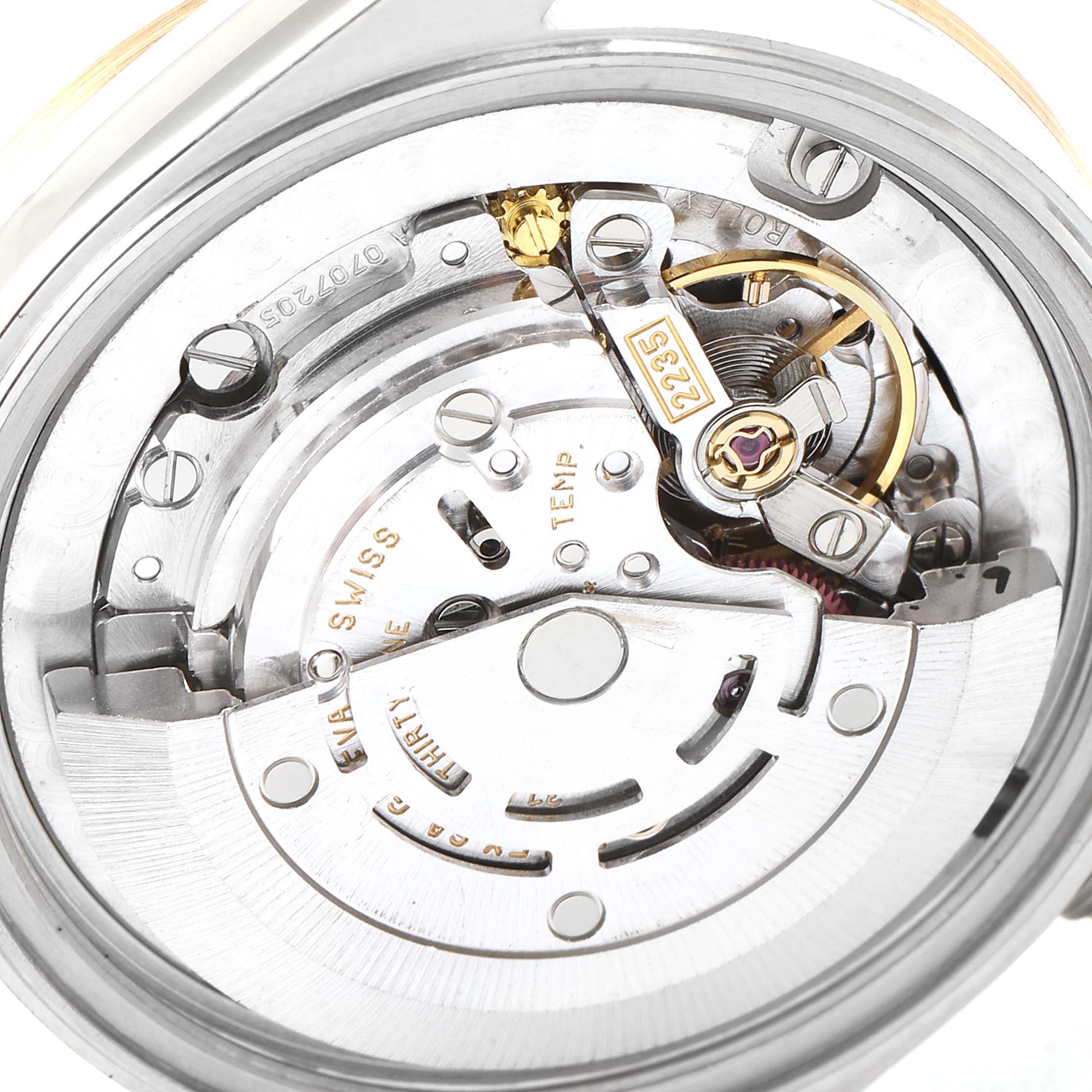 The image shows a close-up view of the movement of a Mid-Size Rolex watch.