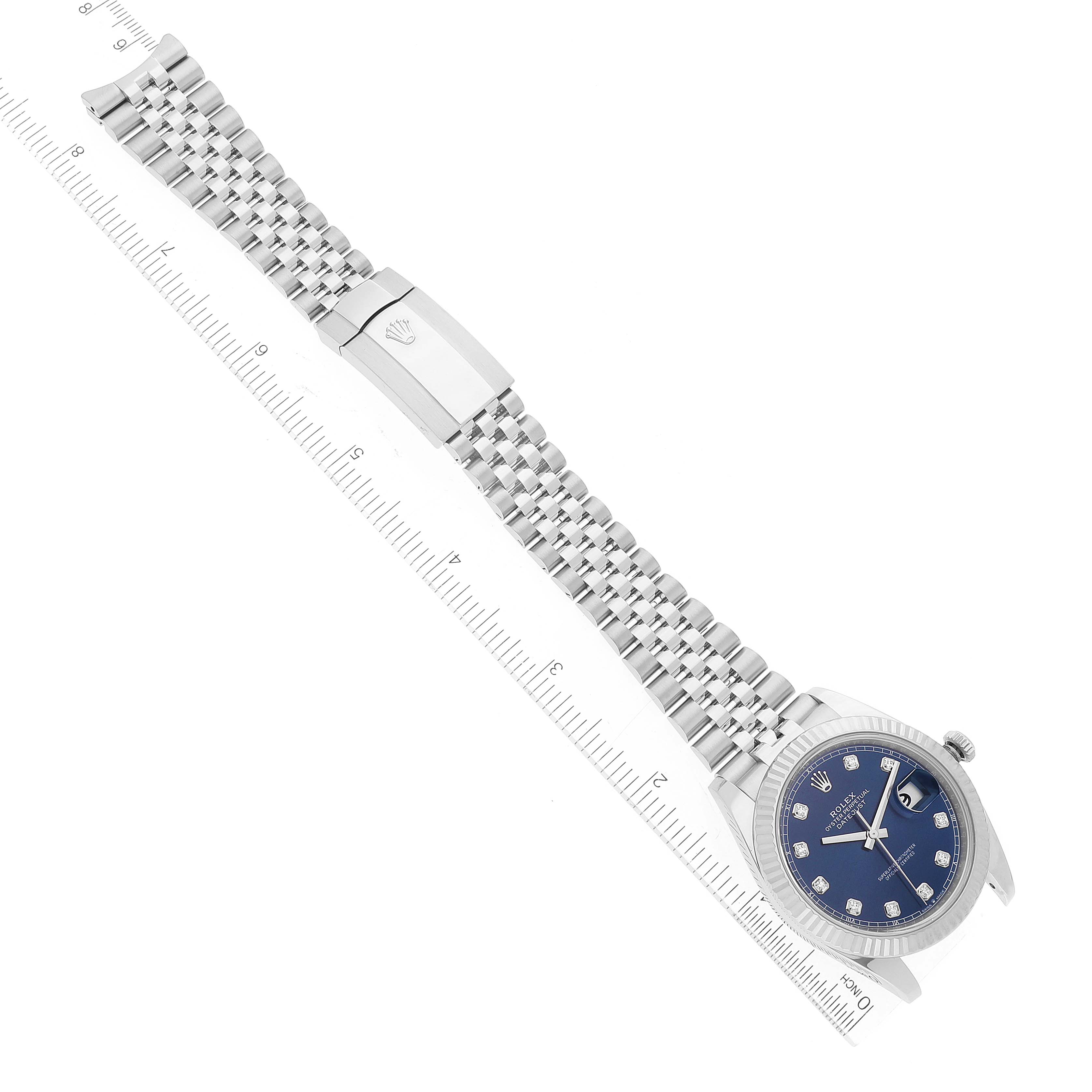 The image shows a Rolex Datejust 41 126334 Men's Stainless Steel Blue Dial 126334 Men's Stainless Steel Blue Dial watch lying flat, displaying the full bracelet, clasp, and a portion of a measurement ruler.