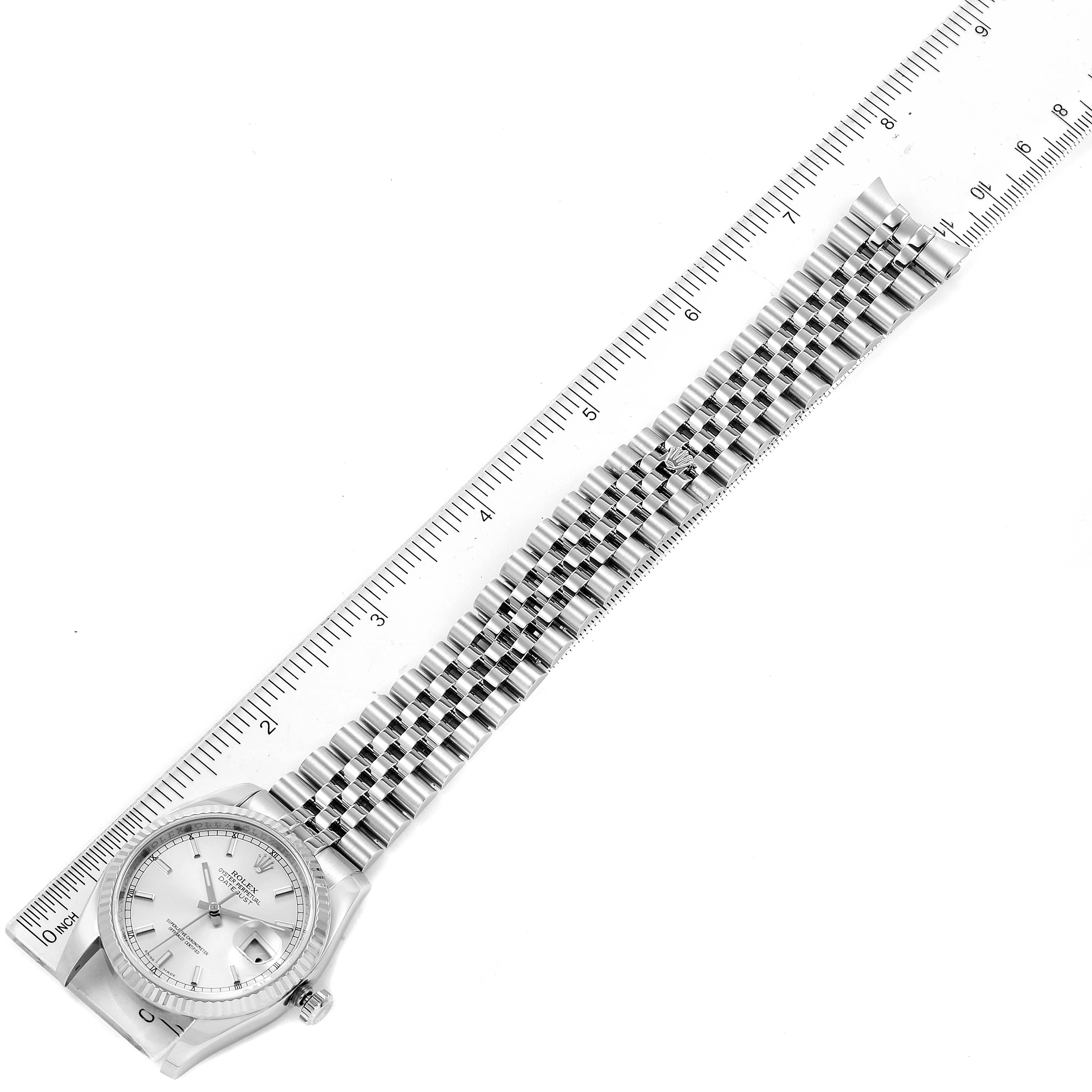 The image shows a Rolex Datejust 116234 Men's Stainless Steel Silver Dial 116234 Men's Stainless Steel Silver Dial watch laid flat alongside a measuring ruler to display its length.