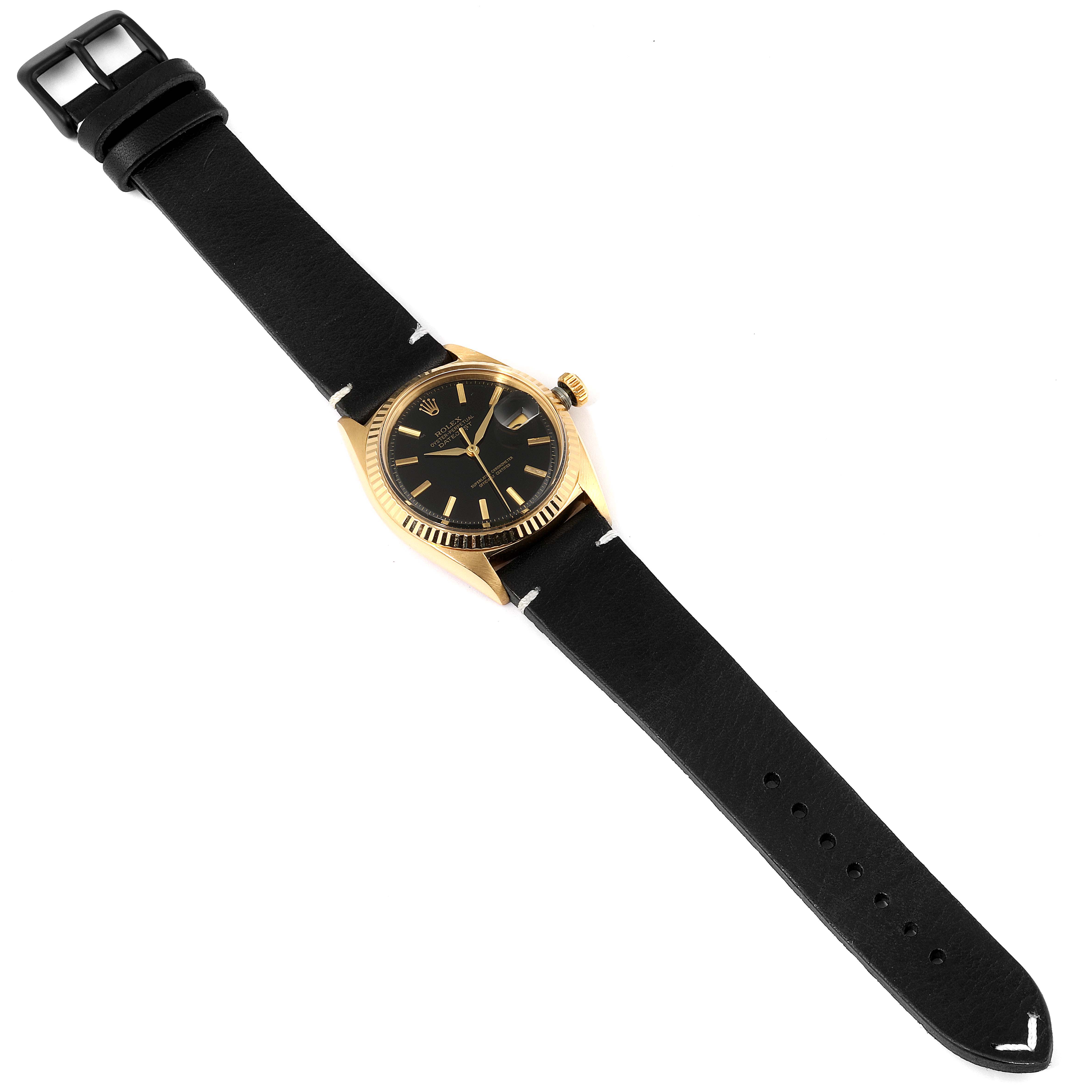 The image shows a Rolex Datejust 1601 Men's Yellow Gold Black Dial 1601 Men's Yellow Gold Black Dial watch from a top-down angle, featuring a black leather strap and a black dial with a gold bezel.