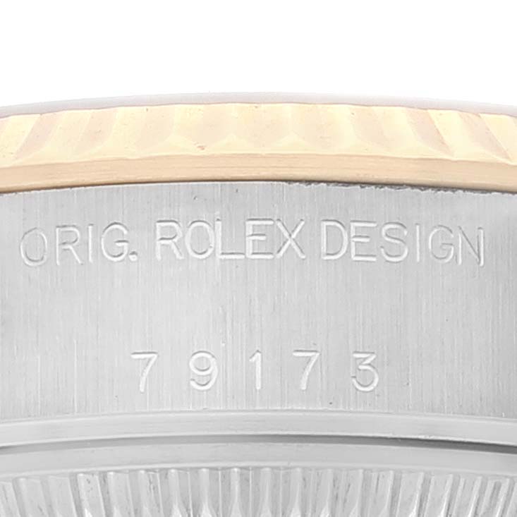 This image shows a close-up view of the Rolex Datejust 79173 Women's Steel and Gold (two tone) Champagne Dial 79173 Women's Steel and Gold (two tone) Champagne Dial bezel and case, featuring the engraved model number and "Orig. Rolex Design".