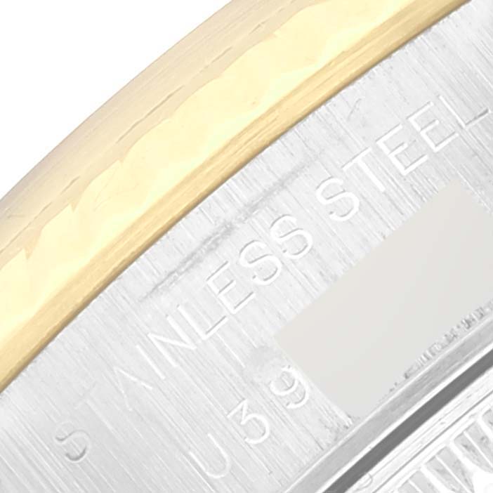 This is a close-up of the bezel and part of the case back of a Rolex Datejust 69173 Women's Steel and Gold (two tone) Mother of Pearl Dial 69173 Women's Steel and Gold (two tone) Mother of Pearl Dial, highlighting its "STAINLESS STEEL" engraving.