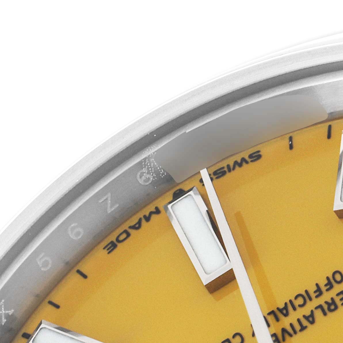 This image shows a close-up of the top-left edge of the Rolex Mid-Size 277200 Women's Stainless Steel Yellow Dial 277200 Women's Stainless Steel Yellow Dial watch face, focusing on the bezel, dial, and markers.