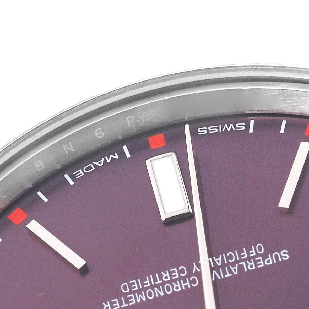 The image shows a close-up of the purple dial, bezel, and part of the indices of a Rolex Oyster Perpetual 114300 Men's Stainless Steel Red Dial 114300 Men's Stainless Steel Red Dial watch.