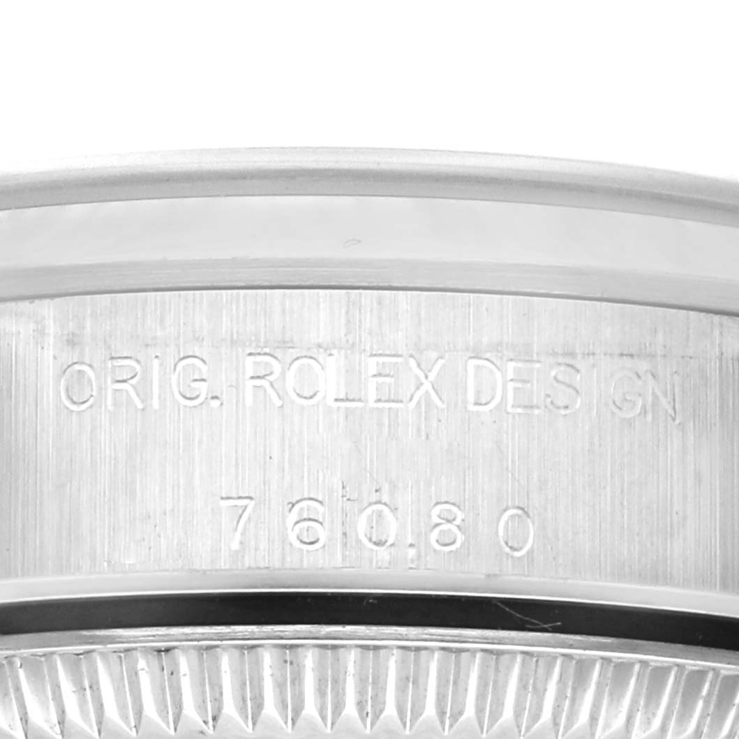 The image shows a close-up of the side of a Rolex Oyster Perpetual 76080 Women's Stainless Steel Pink Dial 76080 Women's Stainless Steel Pink Dial watch, displaying engraved text.