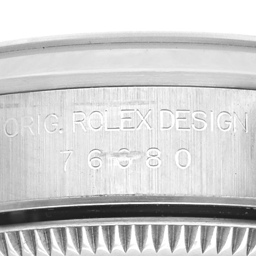 The image shows a close-up of the side of a Rolex Oyster Perpetual 76080 Women's Stainless Steel Pink Dial 76080 Women's Stainless Steel Pink Dial watch, highlighting its engraved design code.