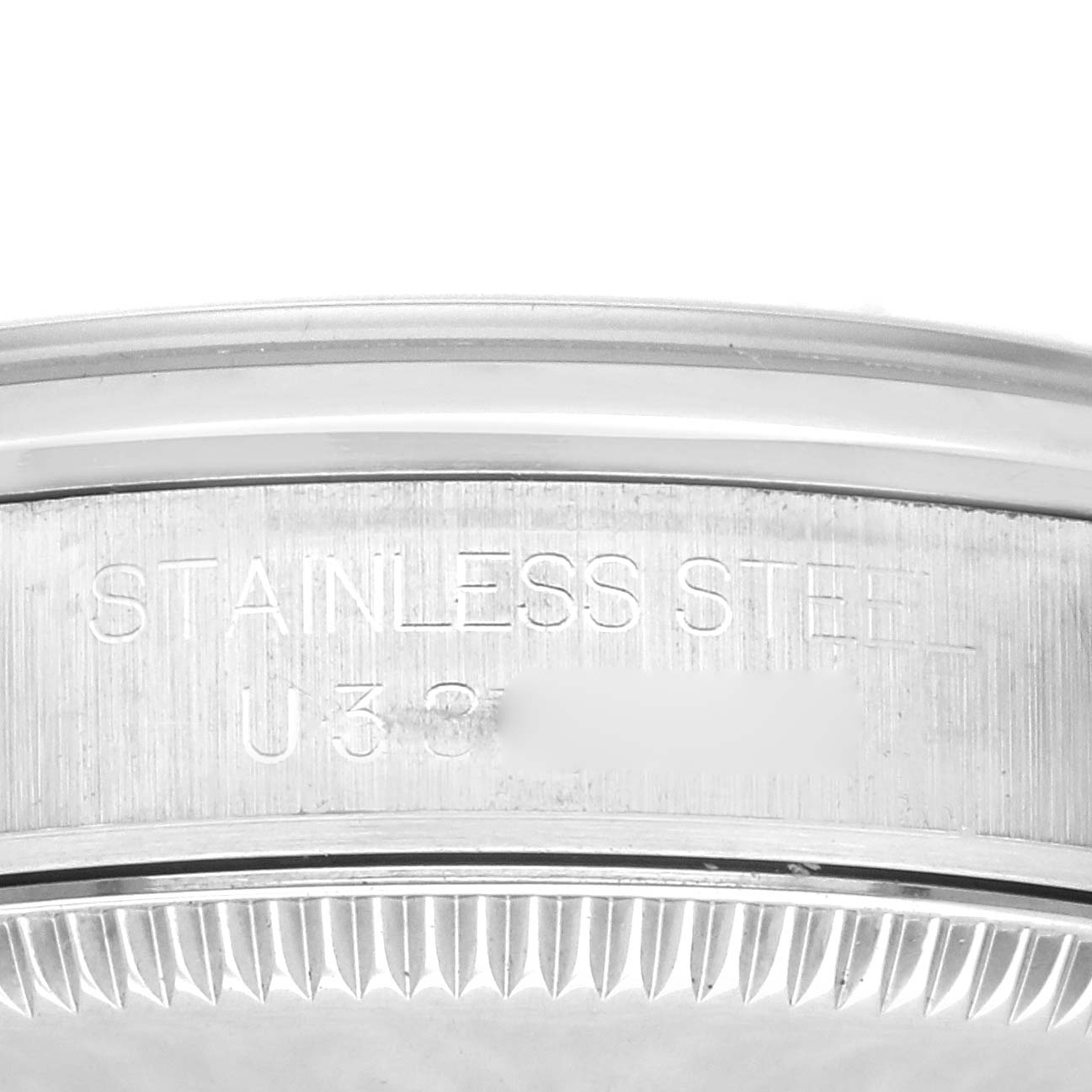 This image shows a close-up of the case back edge and serial number of a Rolex Oyster Perpetual watch.
