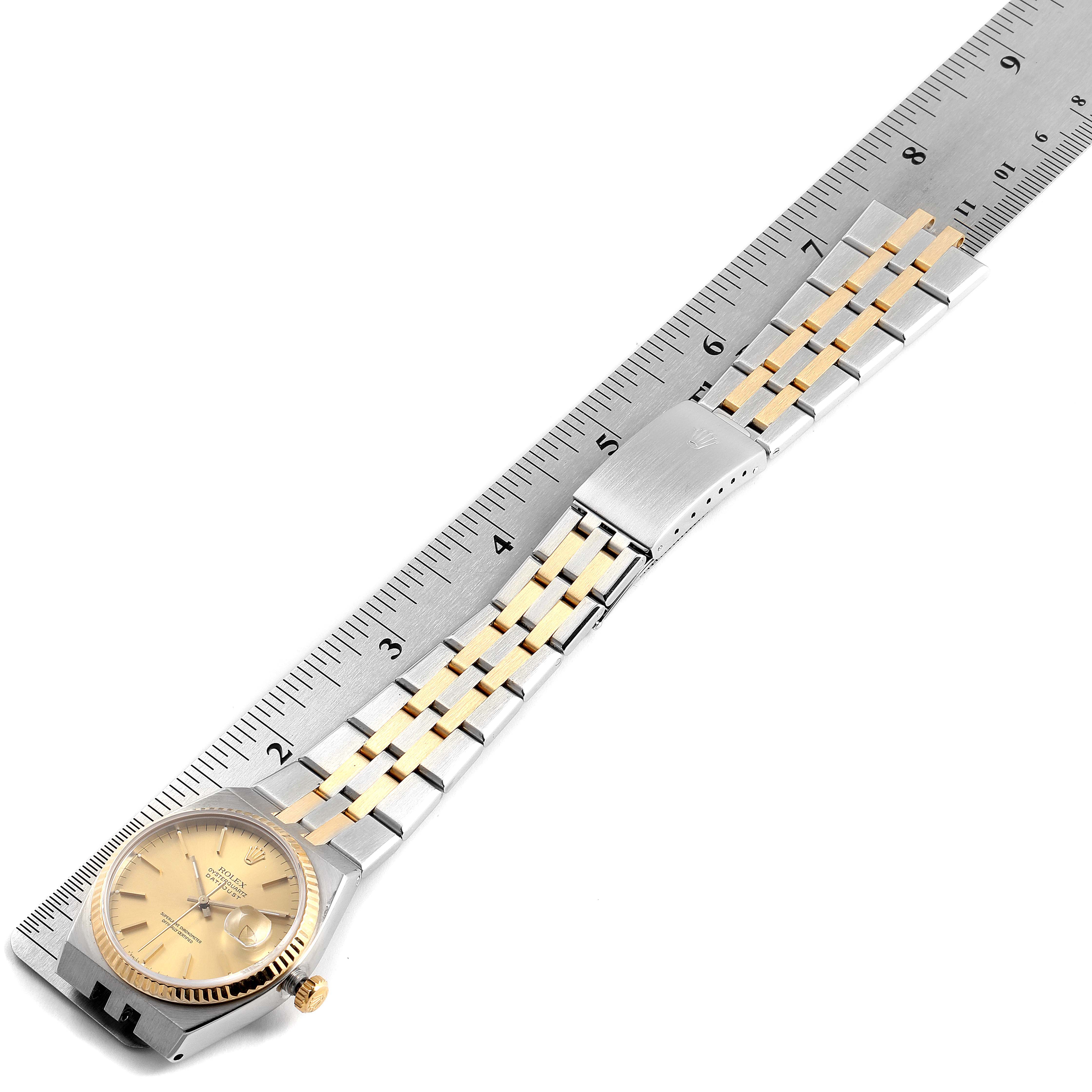 This image shows a Rolex Oysterquartz 17013 Men's Steel and Gold (two tone) Champagne Dial 17013 Men's Steel and Gold (two tone) Champagne Dial watch laid flat, highlighting the bracelet and bezel against a ruler for scale.