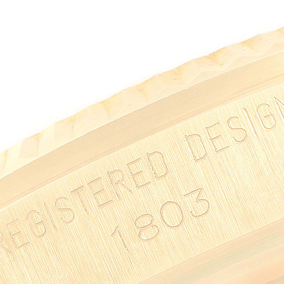 This close-up image shows the side engraving of a Rolex President 1803 Men
s Yellow Gold Silver Dial 1803 Men
s Yellow Gold Silver Dial model, specifically highlighting the "REGISTERED DESIGN 1803" mark.