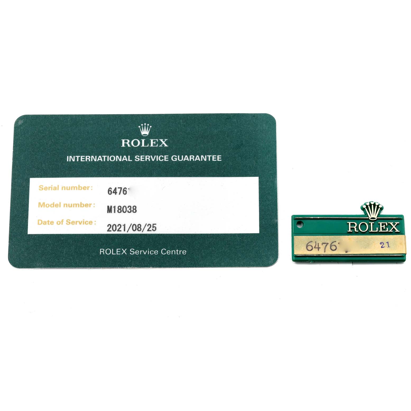The image shows a service guarantee card and a green tag for a Rolex President 18038 Men
s Yellow Gold Champagne Dial 18038 Men
s Yellow Gold Champagne Dial model M18038.