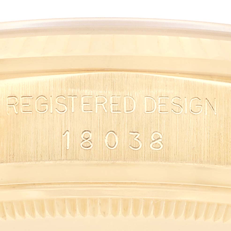 This image shows a close-up of the case of the Rolex President 18038 Men
s Yellow Gold Champagne Dial 18038 Men
s Yellow Gold Champagne Dial model, displaying the "Registered Design" engraving and model number 18038.