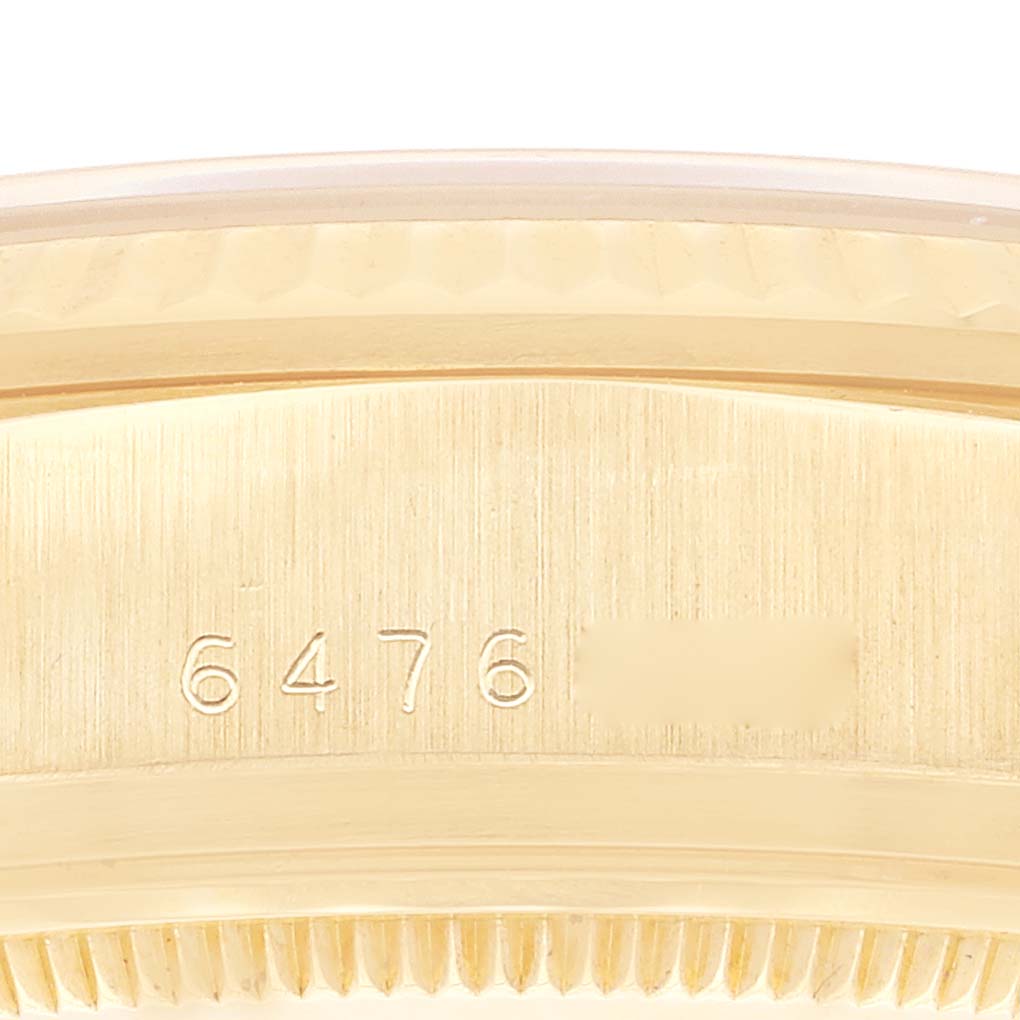 The image shows a close-up of the side of a Rolex President 18038 Men
s Yellow Gold Champagne Dial 18038 Men
s Yellow Gold Champagne Dial model watch, focusing on the serial number engraving.