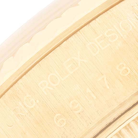 This close-up image shows the engraved side of the bezel on a Rolex President 69178 Women
s Yellow Gold Champagne Dial 69178 Women
s Yellow Gold Champagne Dial model watch.