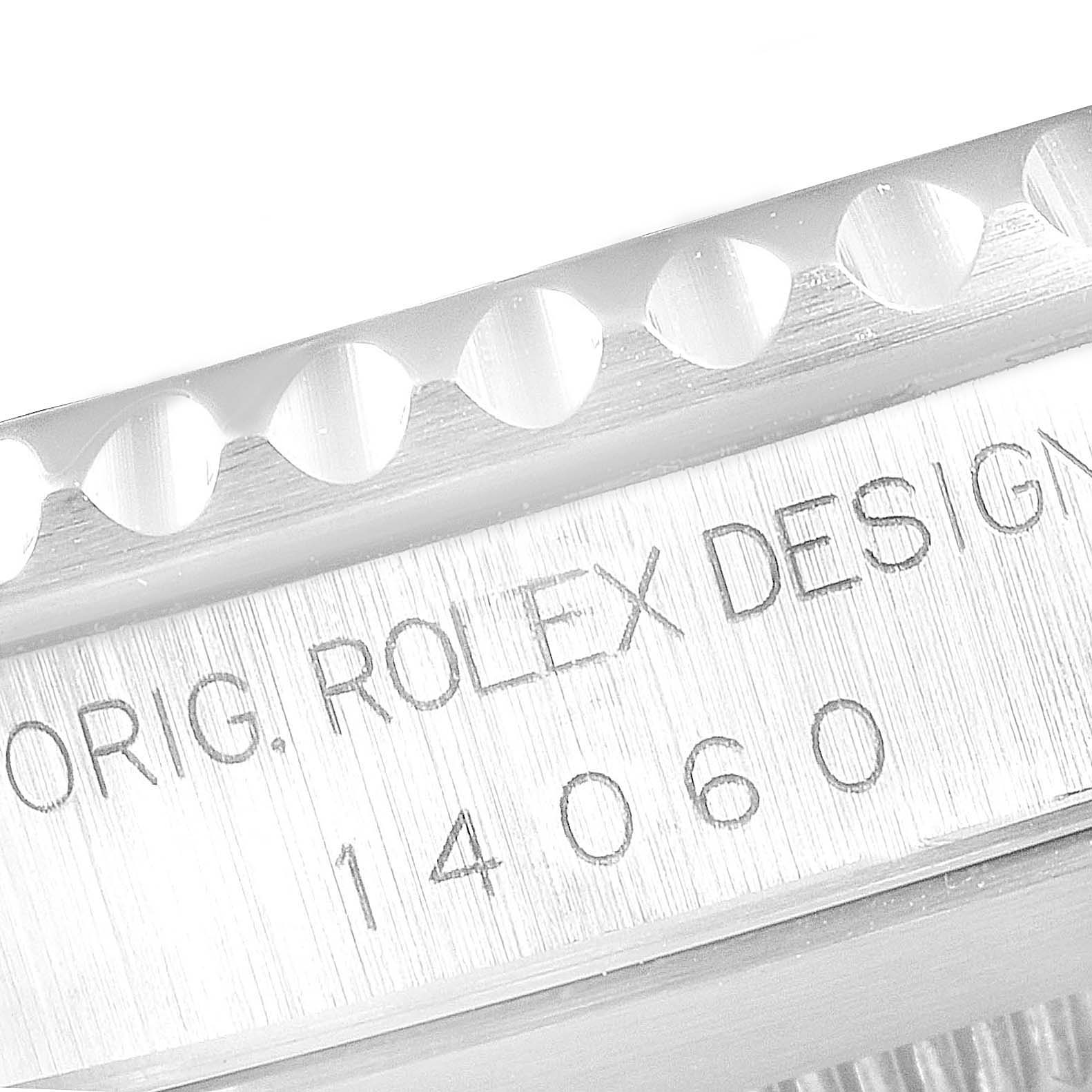 The image shows a close-up of the engraving and bezel edge of a Rolex Submariner 14060 Men
s Stainless Steel Black Dial 14060 Men
s Stainless Steel Black Dial watch.