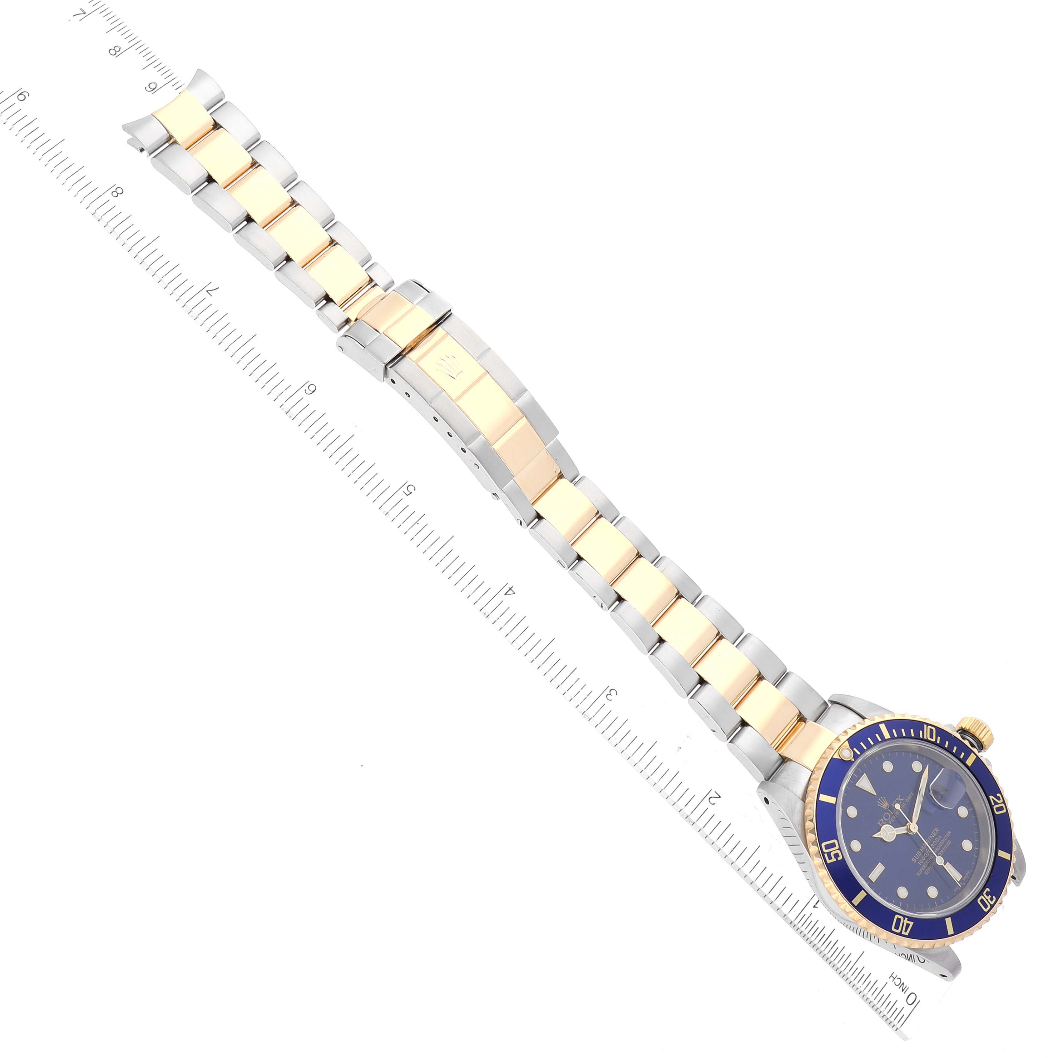 The image shows a top-down view of a Rolex Submariner 16613 Men's Steel and Gold (two tone) Blue Dial 16613 Men's Steel and Gold (two tone) Blue Dial watch, clearly displaying the face, bezel, and bracelet with ruler.