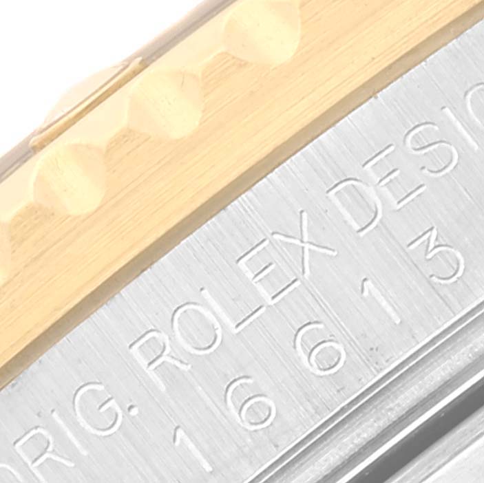 This image shows a close-up of the side of a Rolex Submariner 16613 Men's Steel and Gold (two tone) Blue Dial 16613 Men's Steel and Gold (two tone) Blue Dial, featuring part of the bezel and engraved model details.