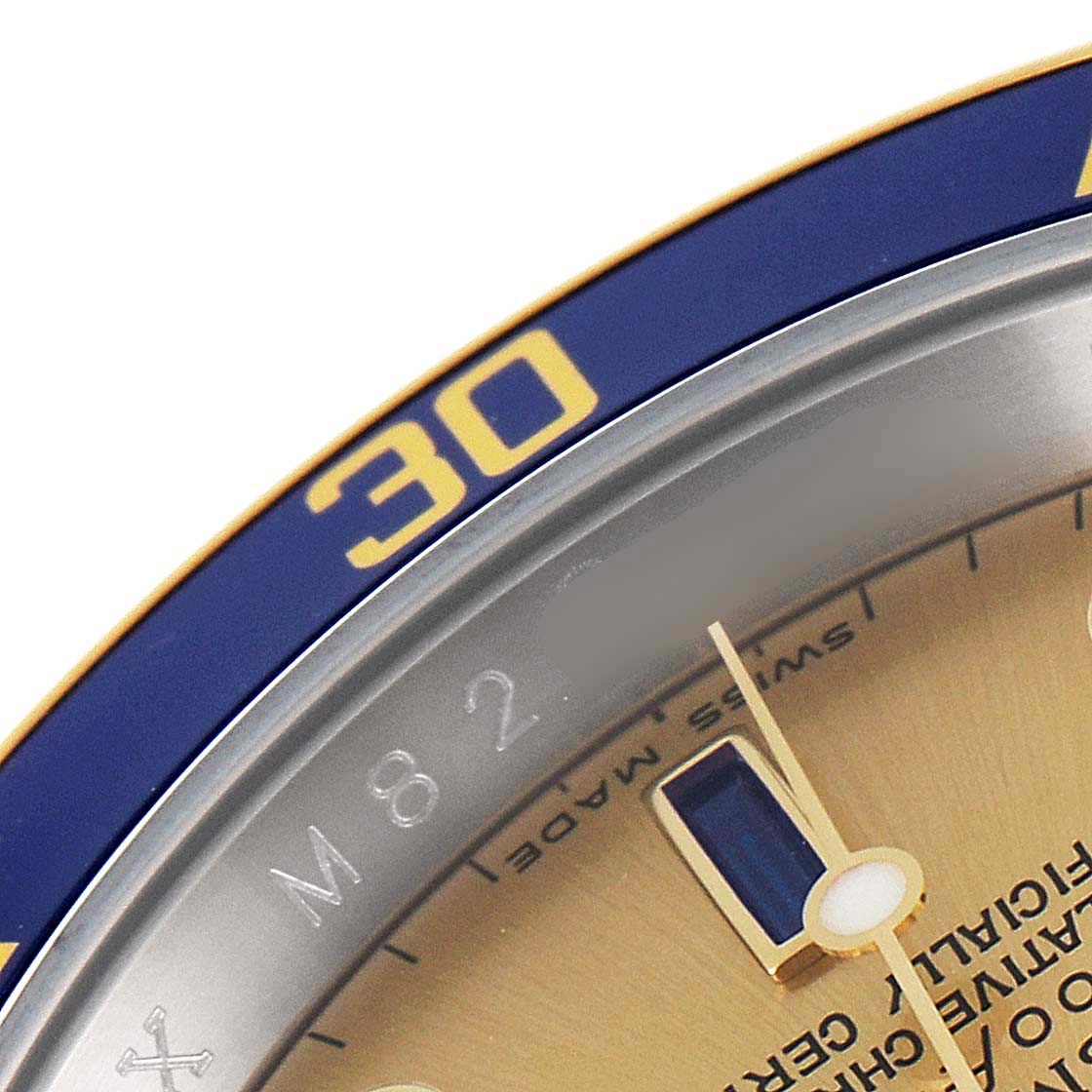 This close-up image of a Rolex Submariner 16613 Men
s Steel and Gold (two tone) Champagne Dial 16613 Men
s Steel and Gold (two tone) Champagne Dial watch shows part of the blue bezel with the "30" mark, and the minute hand over the dial.