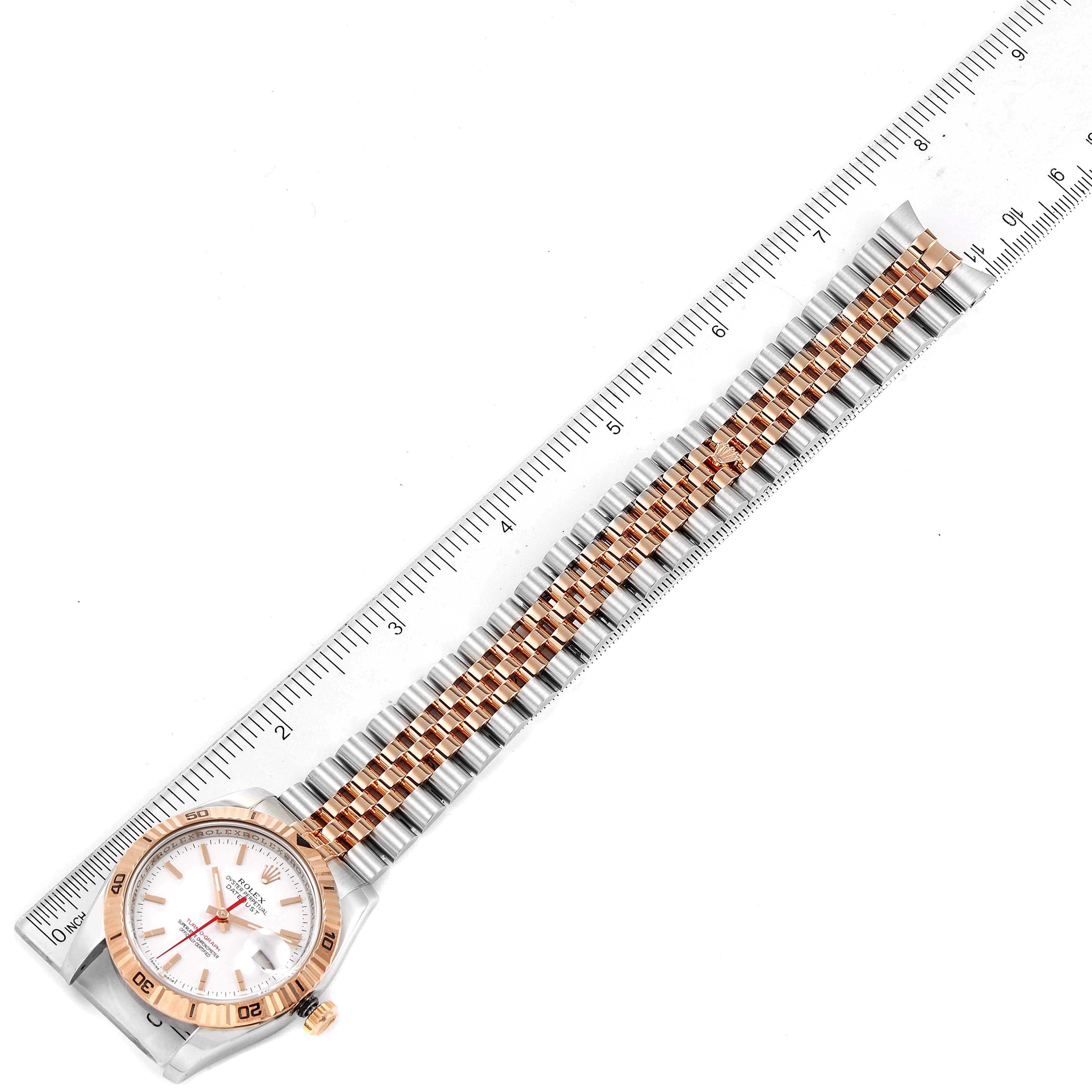 The image shows a Rolex Turn-o-Graph 116261 Men
s Steel and Gold (two tone) White Dial 116261 Men
s Steel and Gold (two tone) White Dial watch from a top view with the bracelet fully extended alongside a ruler.