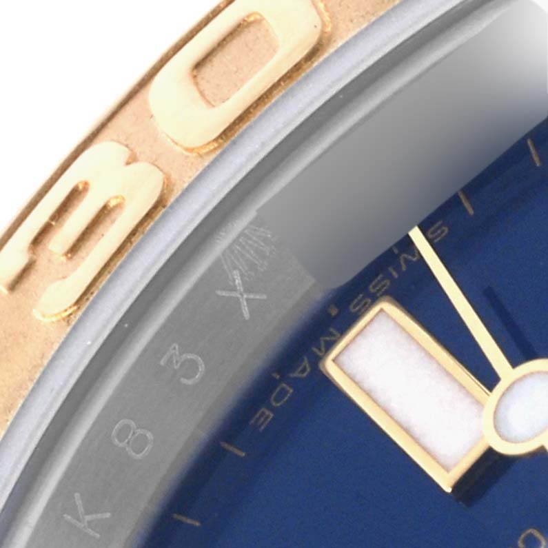 The image shows a close-up of the bezel, dial, and marker of the Rolex Yacht-Master 16623 Men
s Steel and Gold (two tone) Blue Dial 16623 Men
s Steel and Gold (two tone) Blue Dial watch at an angled view.