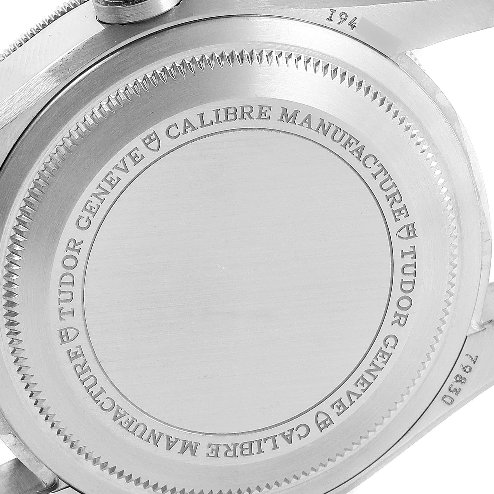 The image shows a close-up of the Heritage Black Bay by Tudor watch case back, displaying the brand and model engravings.