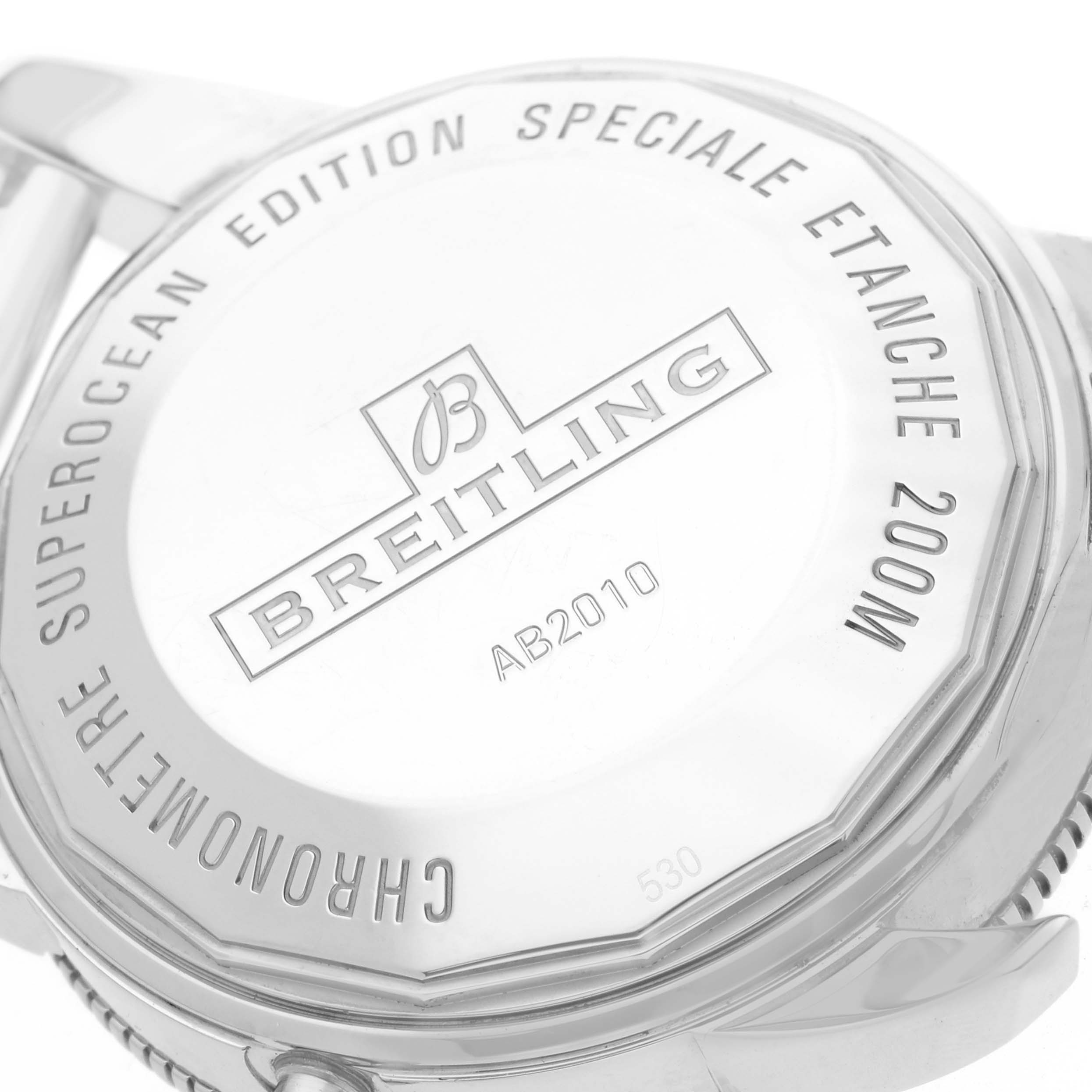 The image shows the back case of a Breitling Superocean AB2010 Men
s Stainless Steel Black Dial watch, displaying engravings and water resistance details at a slight angle.